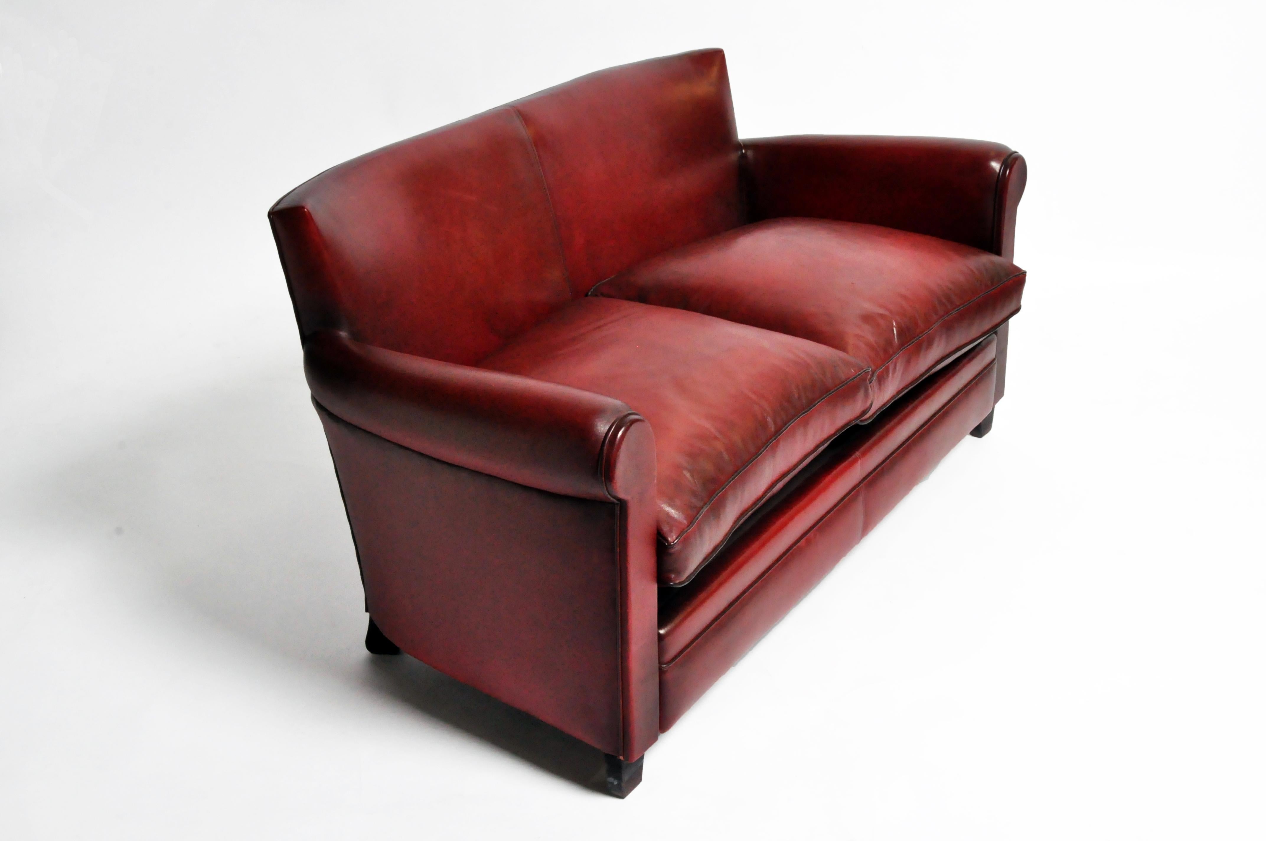 This intimate leather sofa (or loveseat) is newly made in a small atelier near Paris. It is comfortable, sturdy and the lamb leather is unusually soft and supple.