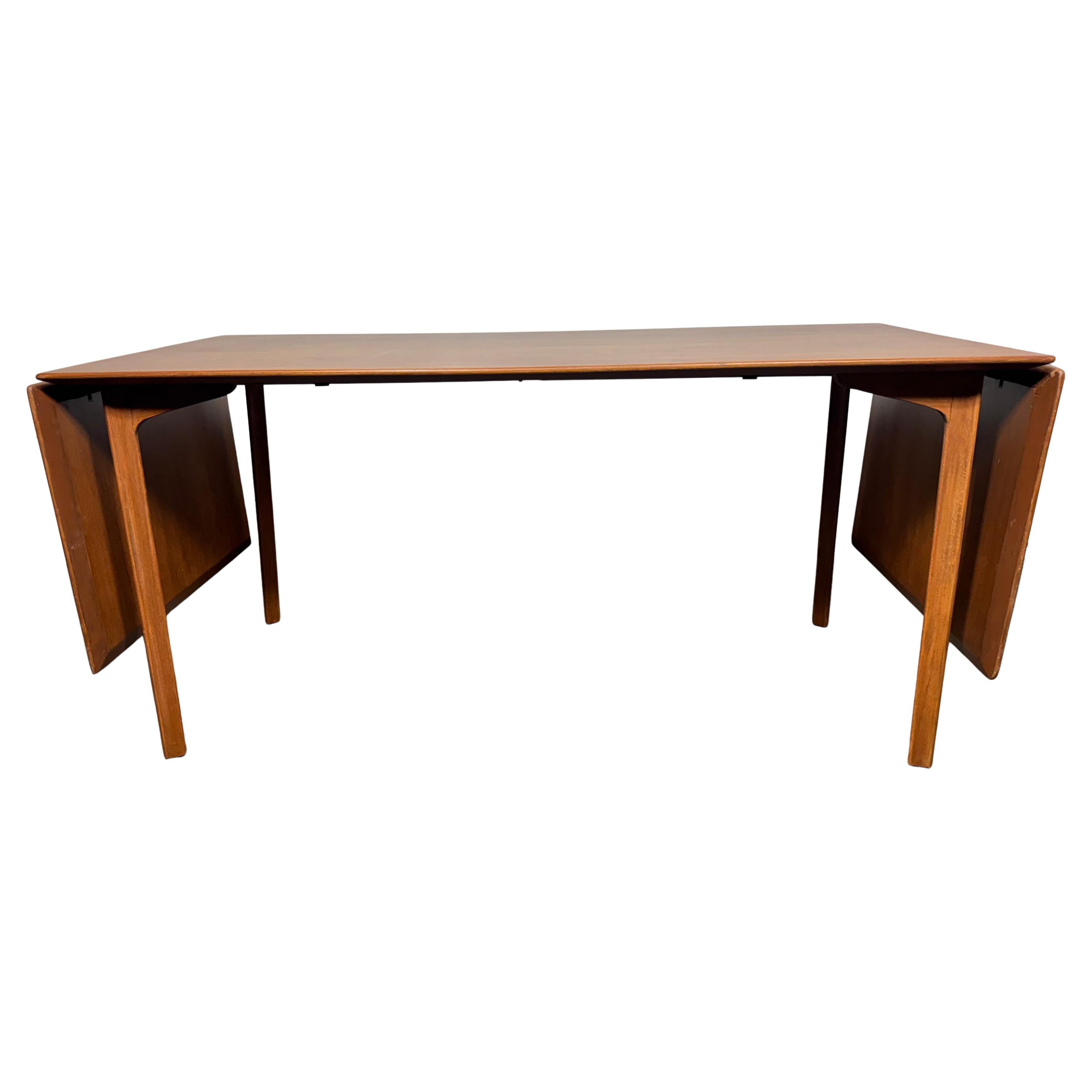 'GRAND PRIX' - Ausziehbarer Esstisch, Teak & Buche  von Arne Jacobsen'. 
 Esstisch 'Grand Prix' mit Fallblättern aus Teakholz und Gestell aus Buche. Mit den Blättern wird die Länge des Tisches um weitere 40