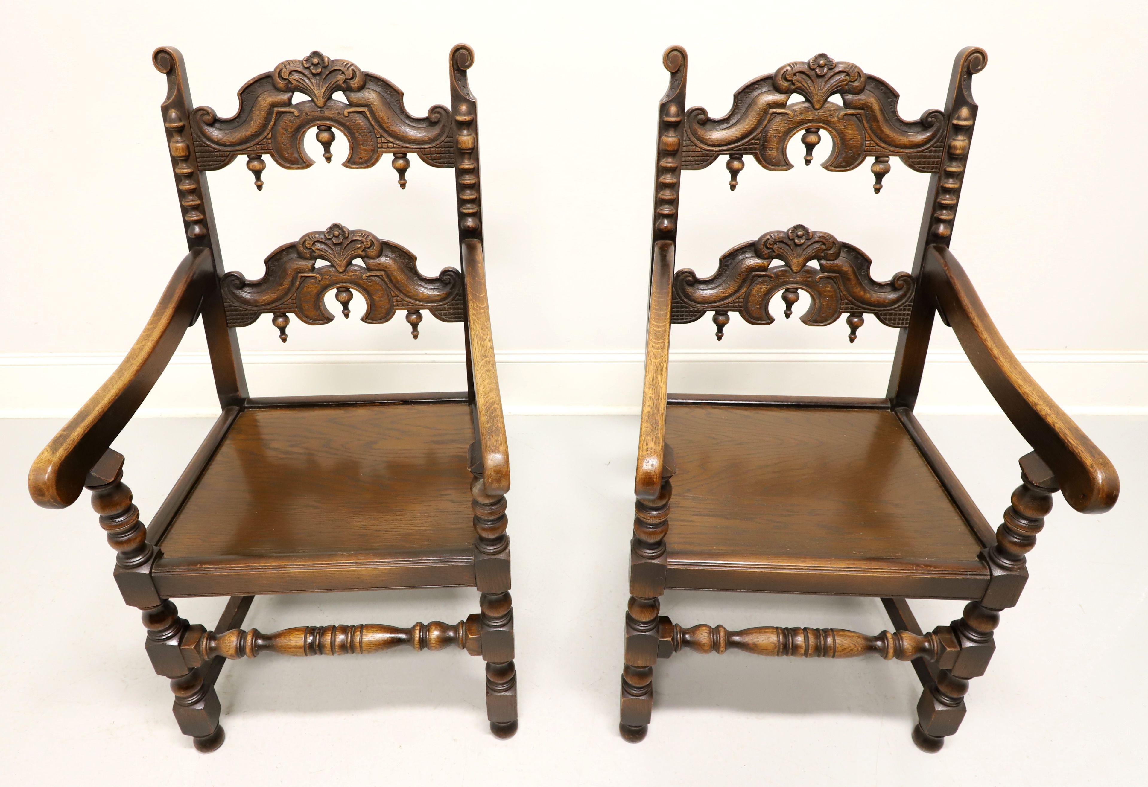 Paire de fauteuils de salle à manger de style néo-gothique de la société Grand Rapids Bookcase and Chair Company. Chêne massif avec détails sculptés et tournés. Le dossier est en forme d'échelle avec des fleurons inversés, les montants sont