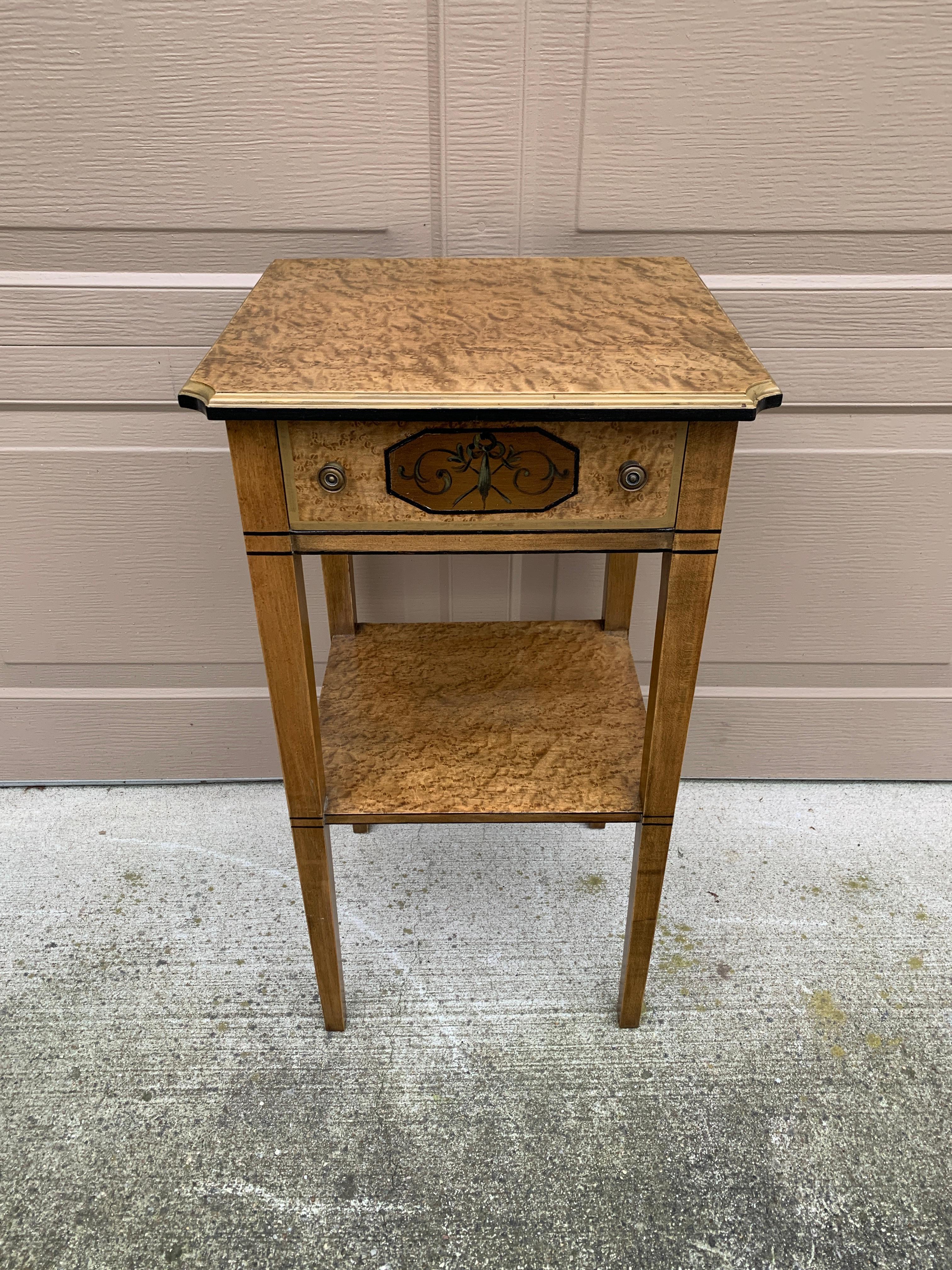 Un bellissimo comodino o tavolino in acero dipinto in stile Regency con dettagli dipinti in stile classico.

Da Imperial Furniture, Grand Rapids

USA, circa anni '40

Misure: 15