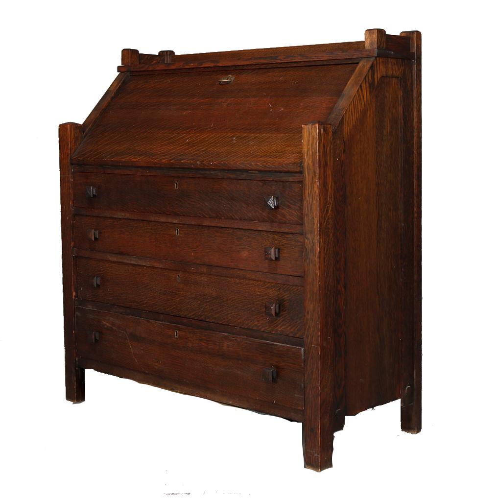 An antique Arts & Crafts Mission secretary by Cron-Kills Co., Piqua, OH offers oak construction paneled sides with slant drop front desk surmounting four long drawers and raised on straight and square legs, original maker label en verso as
