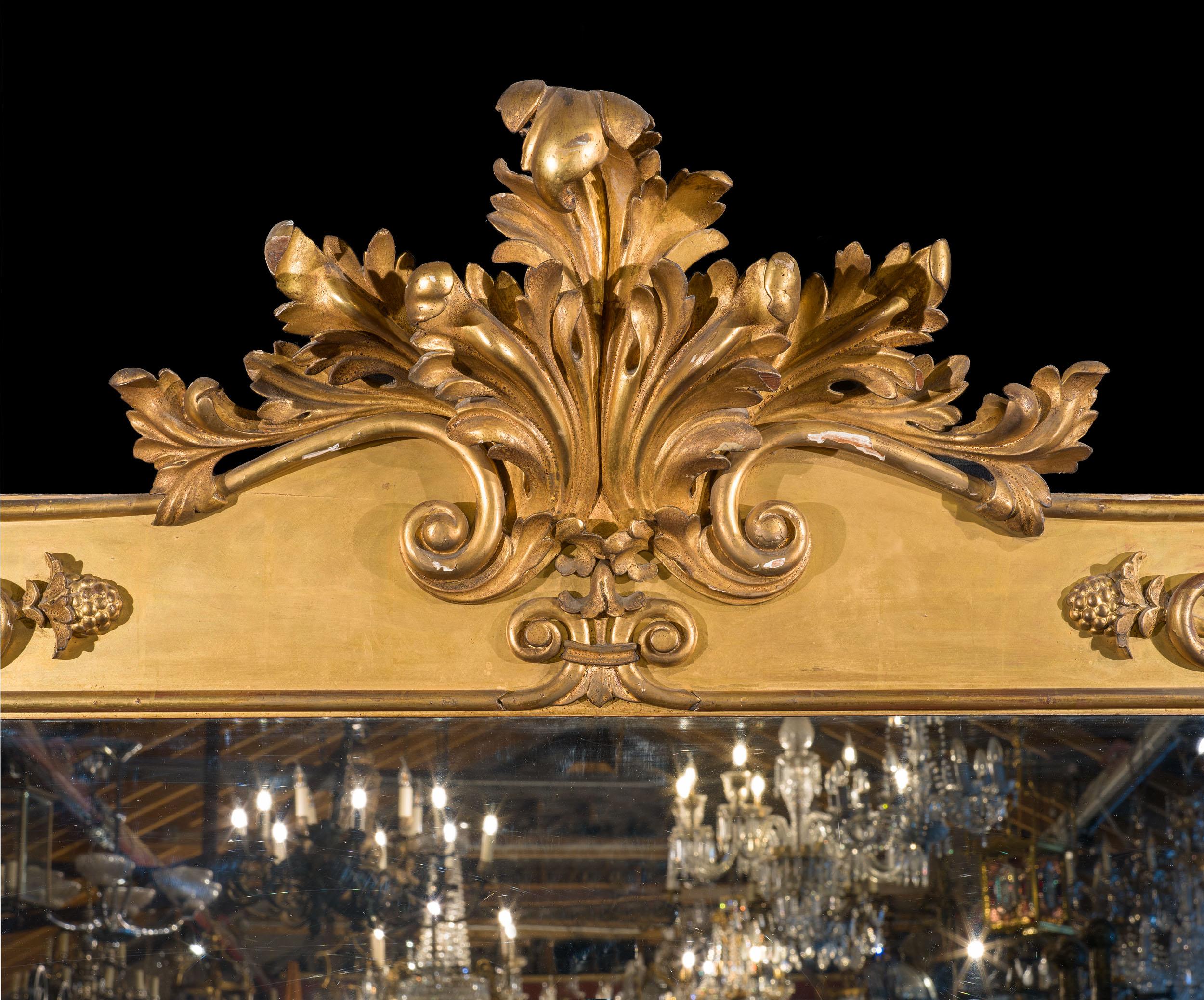 Un grandioso specchio da tavolo della tarda Reggenza di qualità eccezionale. La cornice in legno dorato è riccamente impreziosita da decorazioni acantine e a volute, con uno stemma particolarmente magnifico. Questo racchiude la lastra argentata