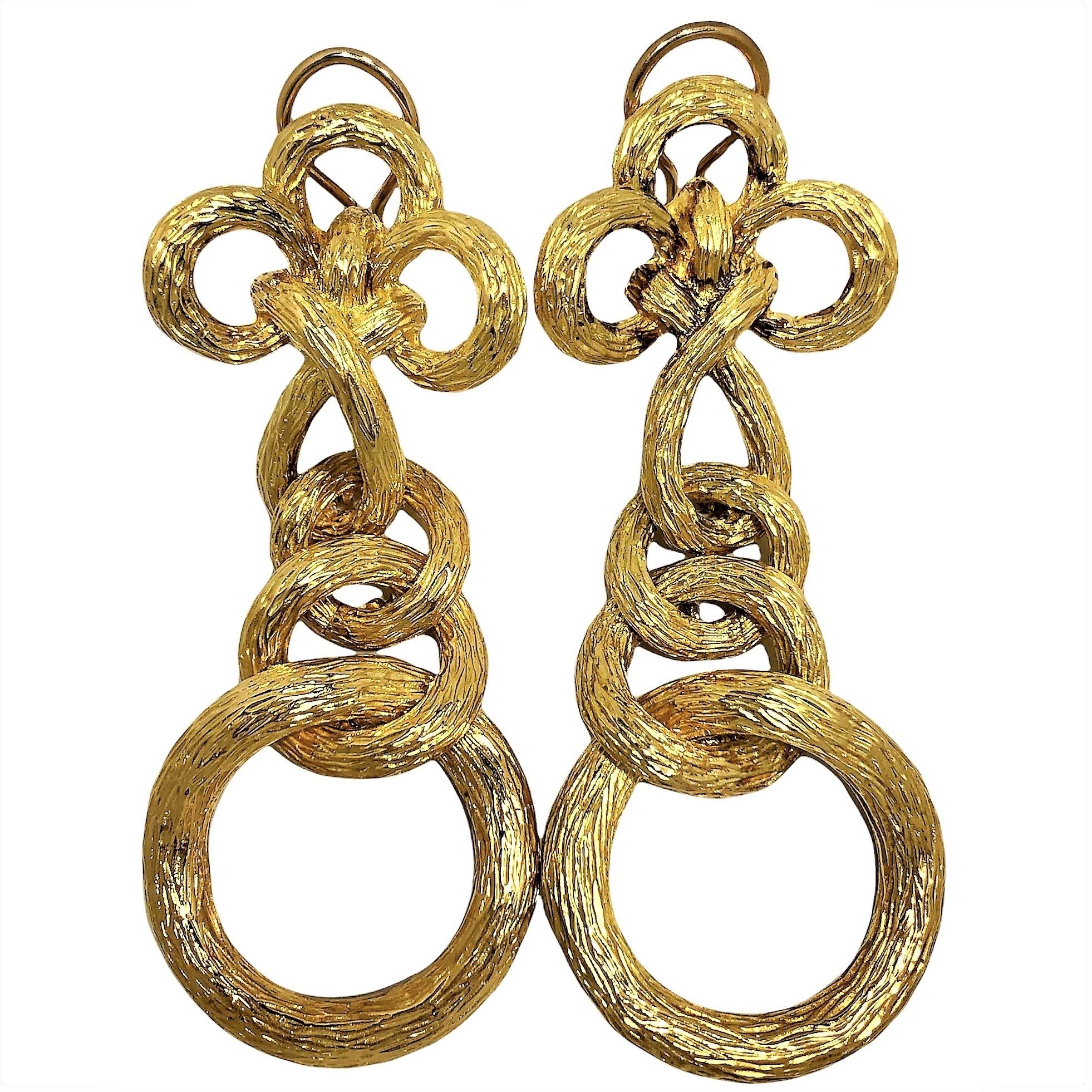 This wonderfully articulated and crafted pair of earrings has movement throughout, with each individual section hinged to the next. The entire surface is hand finished in what is referred to  as 