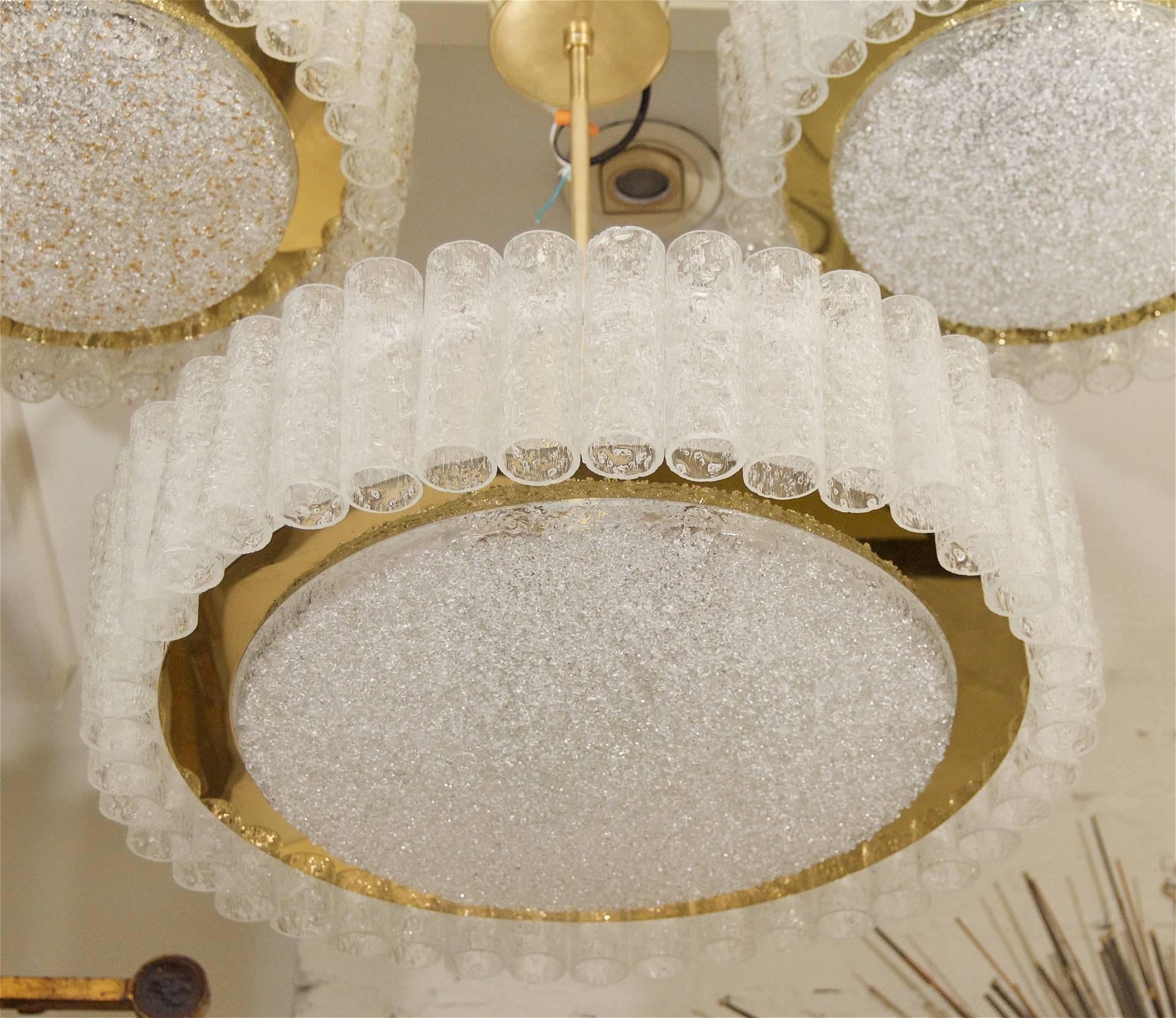 A gorgeous and unusually large Doria chandelier, with individually hung organic ice glass tubes surrounding a brass ring and inner ice glass disk.

Six medium base bulbs up to 60 watts per bulb. New wiring.

Height listed is of chandelier body