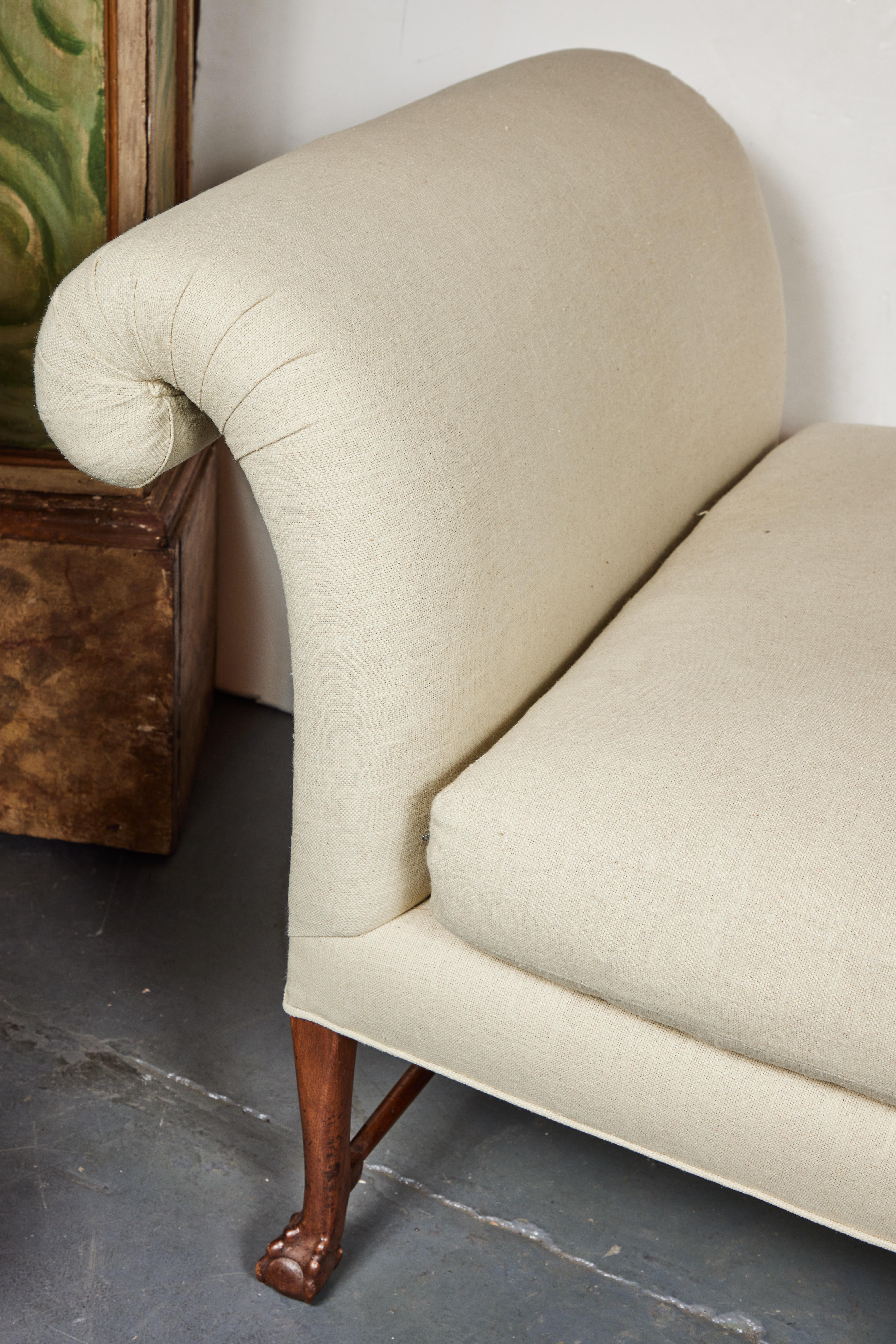 A sizeable, elegant, c. 1935, English divan in mahogany. The whole on a series of eight, webbed, ball and claw feet and surmounted by newly made, down filled, lined covered cushioning.