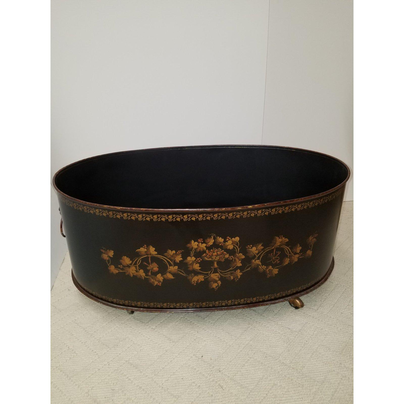 Very large hand painted oval Regency style black and gold planter in the manner of Maitland Smith. The planter which would work well as a log holder with Classic English style gold painted decoration having lion with ring handles with a black