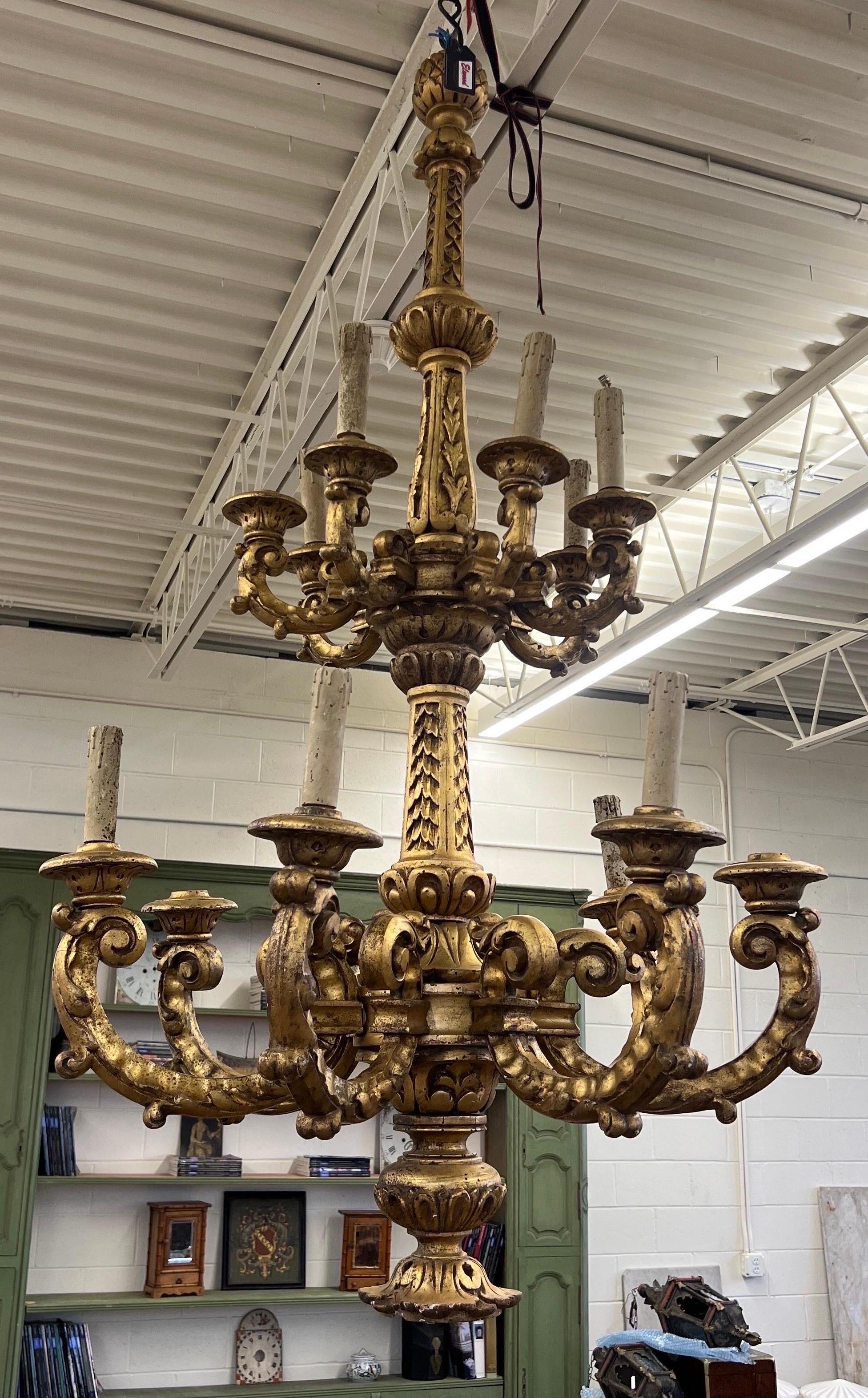 Great quality grand scale late 19th century double tier Italian giltwood chandelier. This statement piece is all hand carved with two tiers of 7 giltwood arms each and has one downward facing socket at the base as well. Recently rewired though still