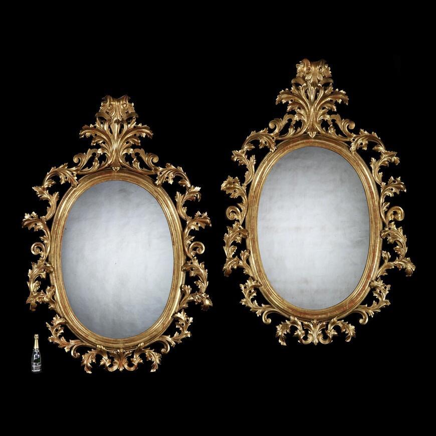 Remarkable pair of extremely large 19th century oval Florentine carved giltwood mirrors standing 2.3 meters high.

European, circa 1880.

Extremely impressive, this decorative and rare pair of open carved oval gilt wood mirrors are of typical