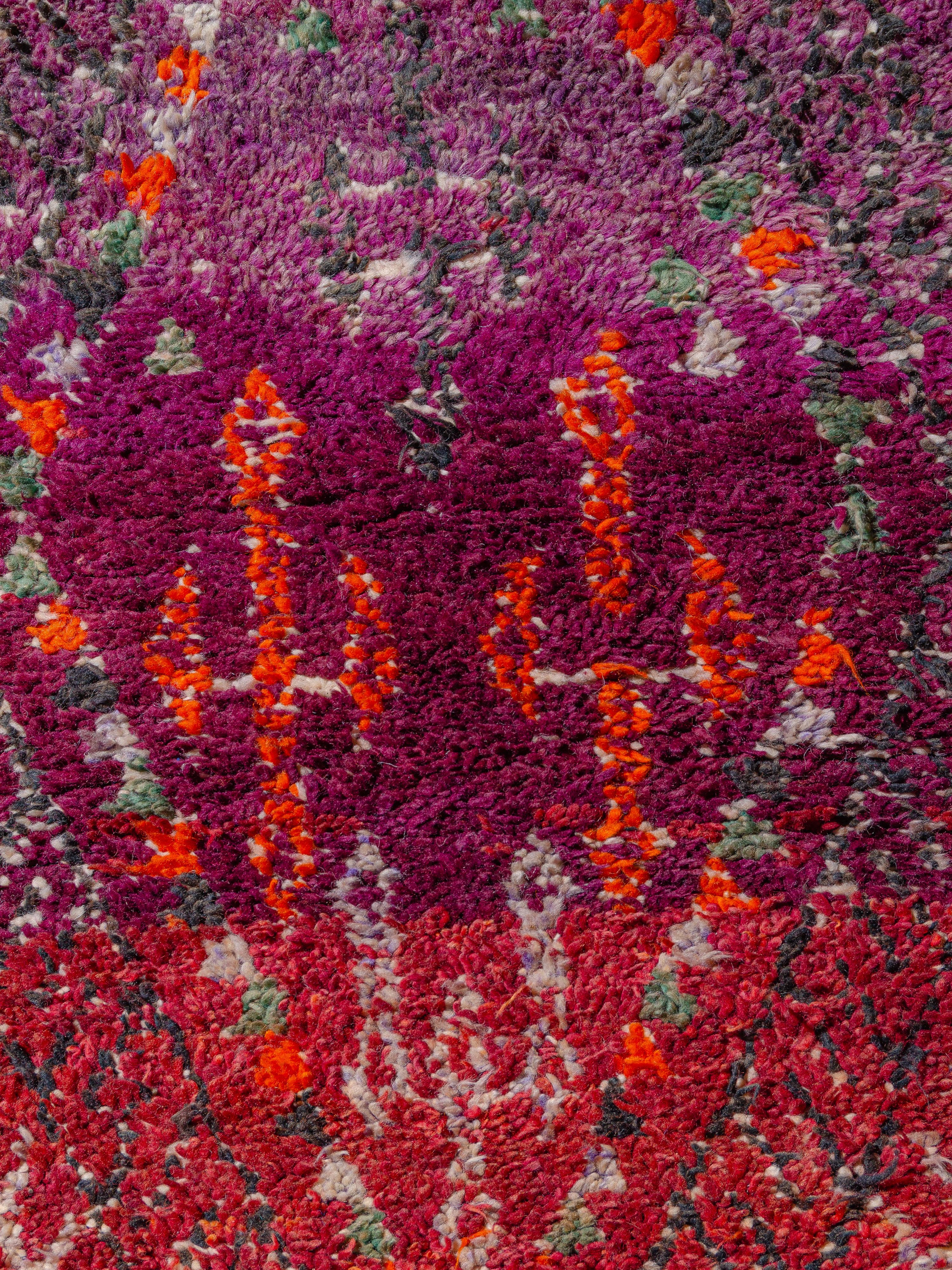 A vintage Moroccan Beni M’Tir featuring large-scale elongated lozenges that appear stretched over the field. The motif network is filled with an array of Berber symbology, including 8-pointed stars, ladders, diamonds, and cross forms. The abrashed