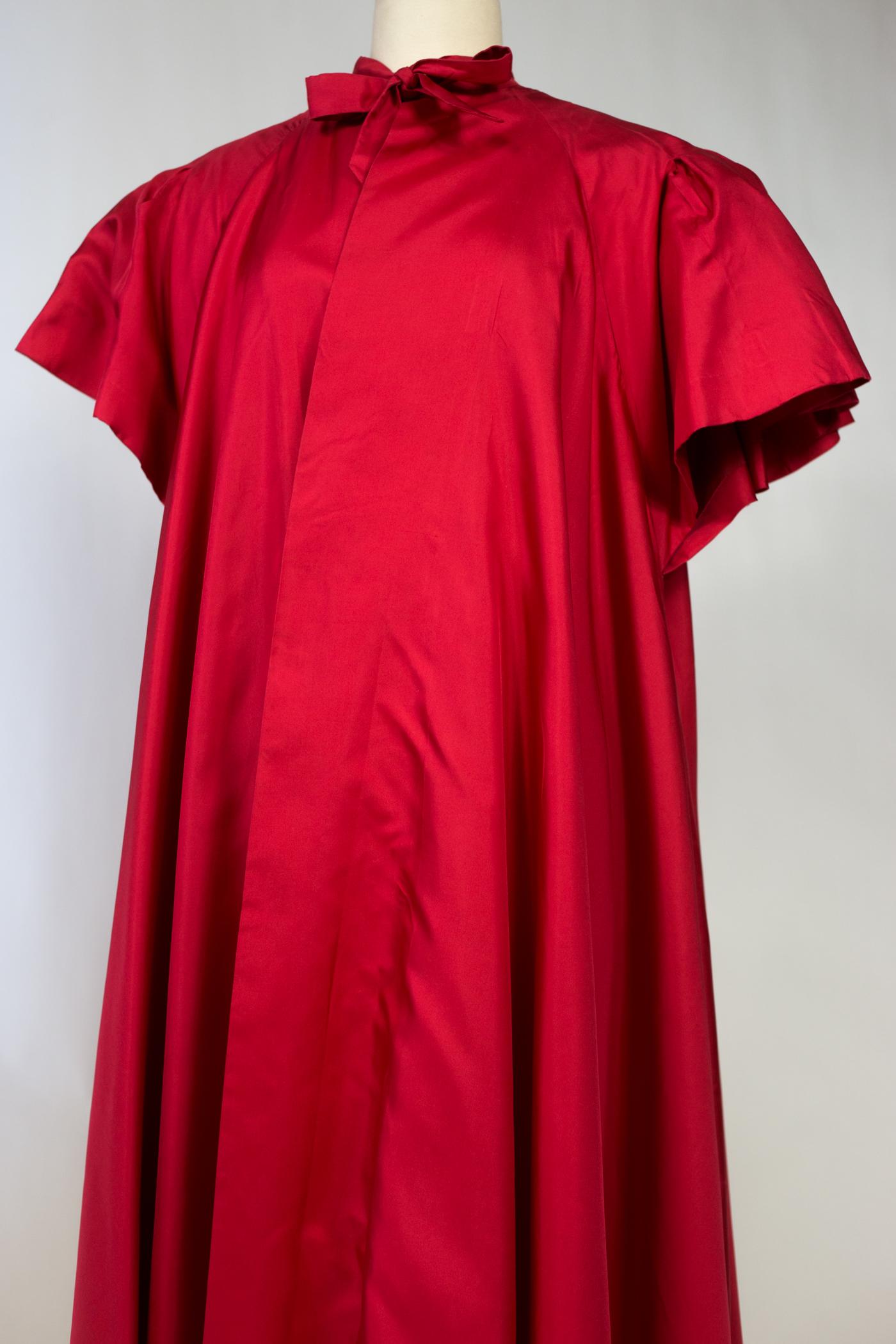 Circa 1955

France

Majestic Cherry red silk twill evening coat by Maggy Rouff Haute Couture dating from the 1950s. Work of sun pleats mounted in godets from the shoulders and widening in volume on the sleeves and the bottom of the coat which