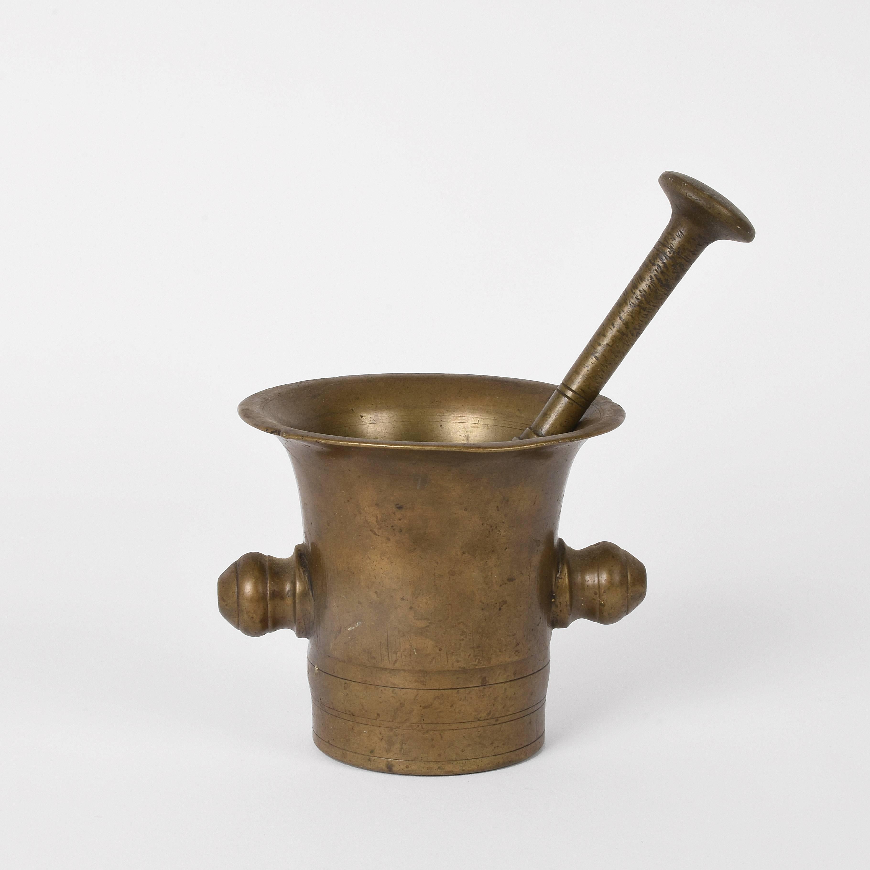 Wonderful and antique handmade bronze mortar with its pestle.

Pharmacists used this scientific instrument to blend herbs and ingredients during the 19th century.

This desk accessory preserves its original patina and would be a perfect gift for