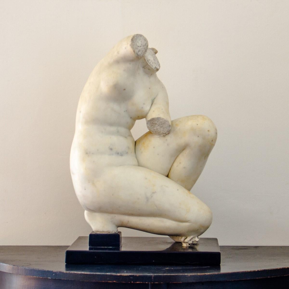 A Grand Tour, After the Antique, early 19th century fragment of the crouching Venus, in white marble and set on an ebonised base. 

The Grand Tour was the traditional trip of Europe undertaken by mainly upper-class European young men of means. The