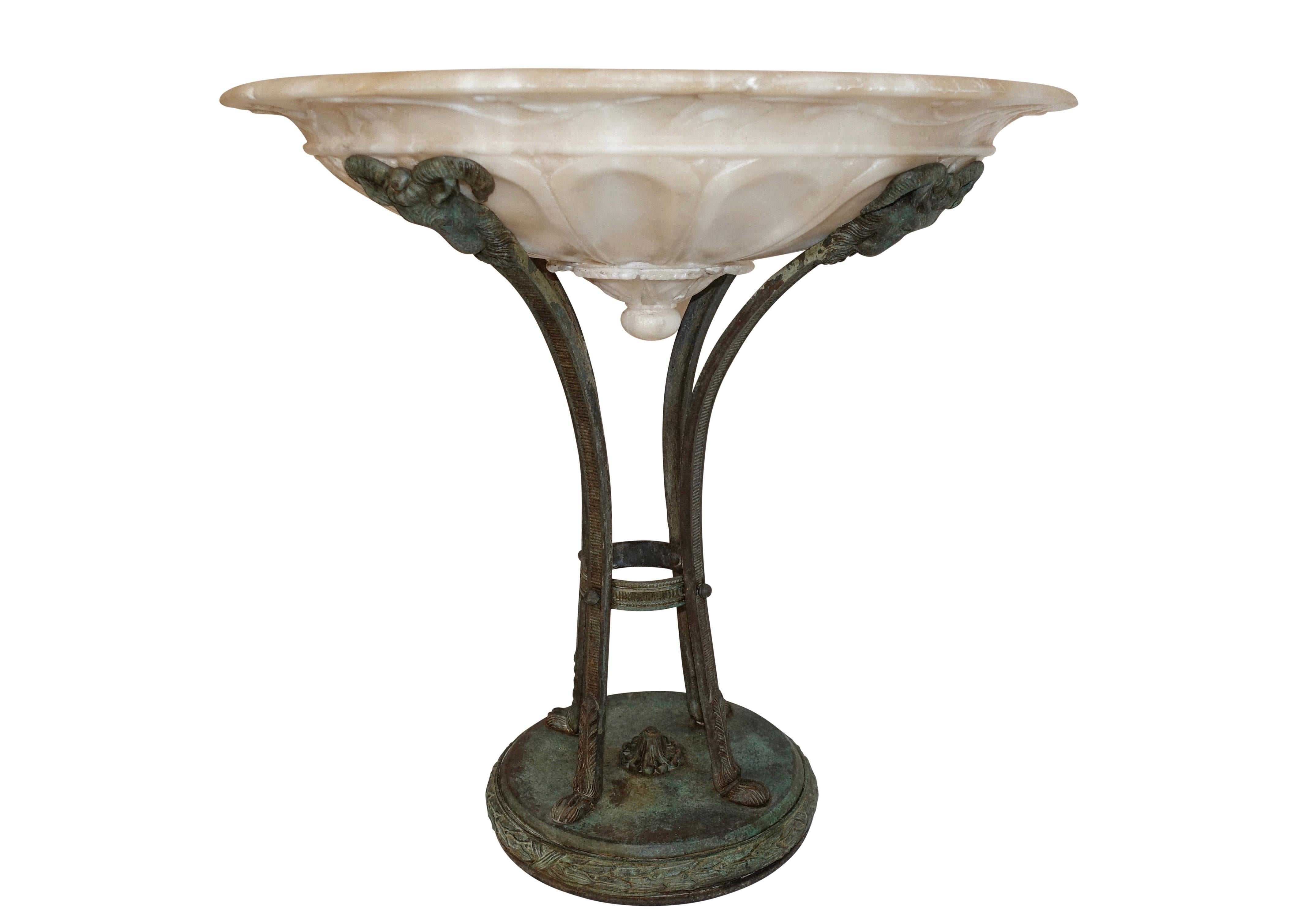 An exuberant alabaster bowl affixed to a rams head bronze stand with paw feet, standing on a circular base of wrapped sheafs of wheat, Italy, circa 1880.