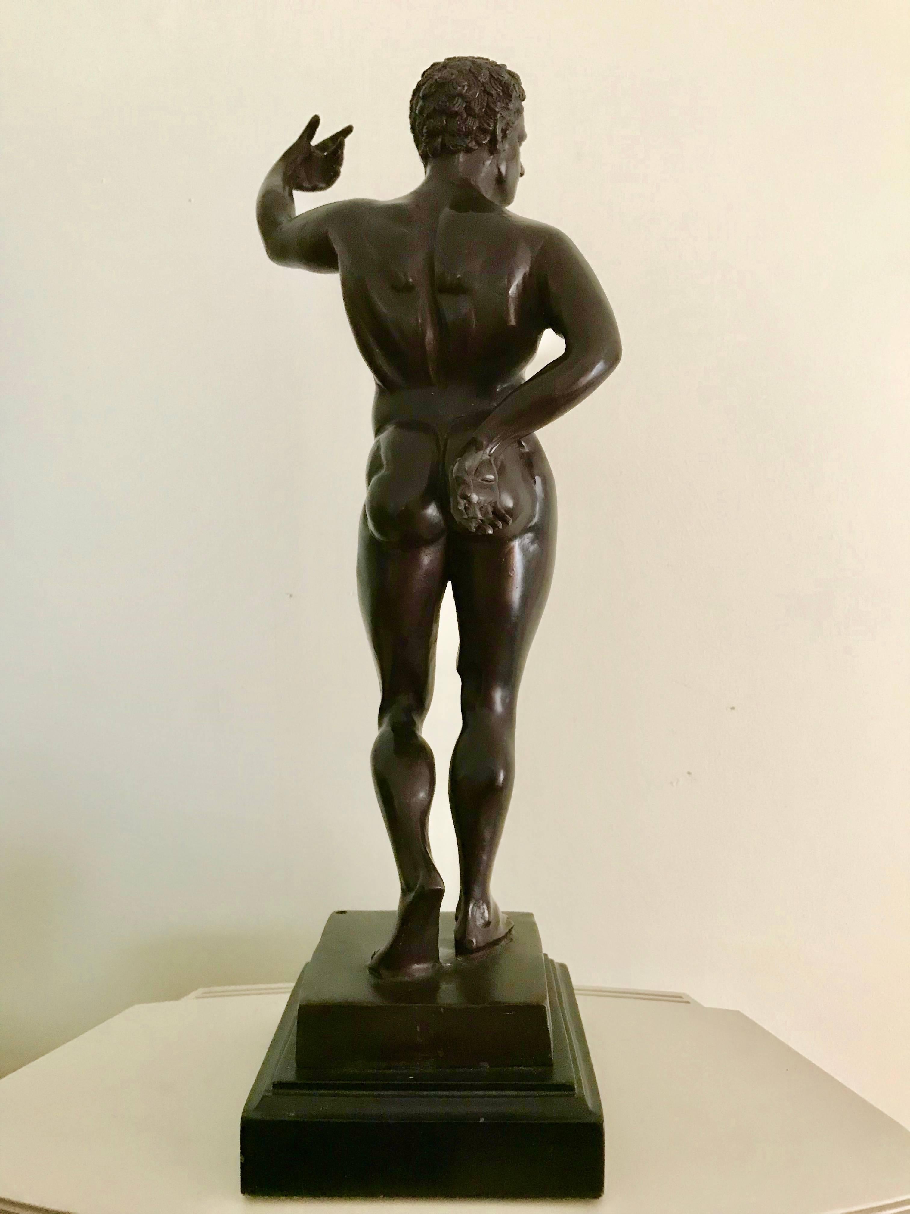 Italian Grand Tour bronze of a standing naked male warrior, his uplifted left arm once held a spear. Modeled after an ancient Roman or Geek original, the figure is shown in a Classic 'contrapposto' stance, with one arm behind the back and one held