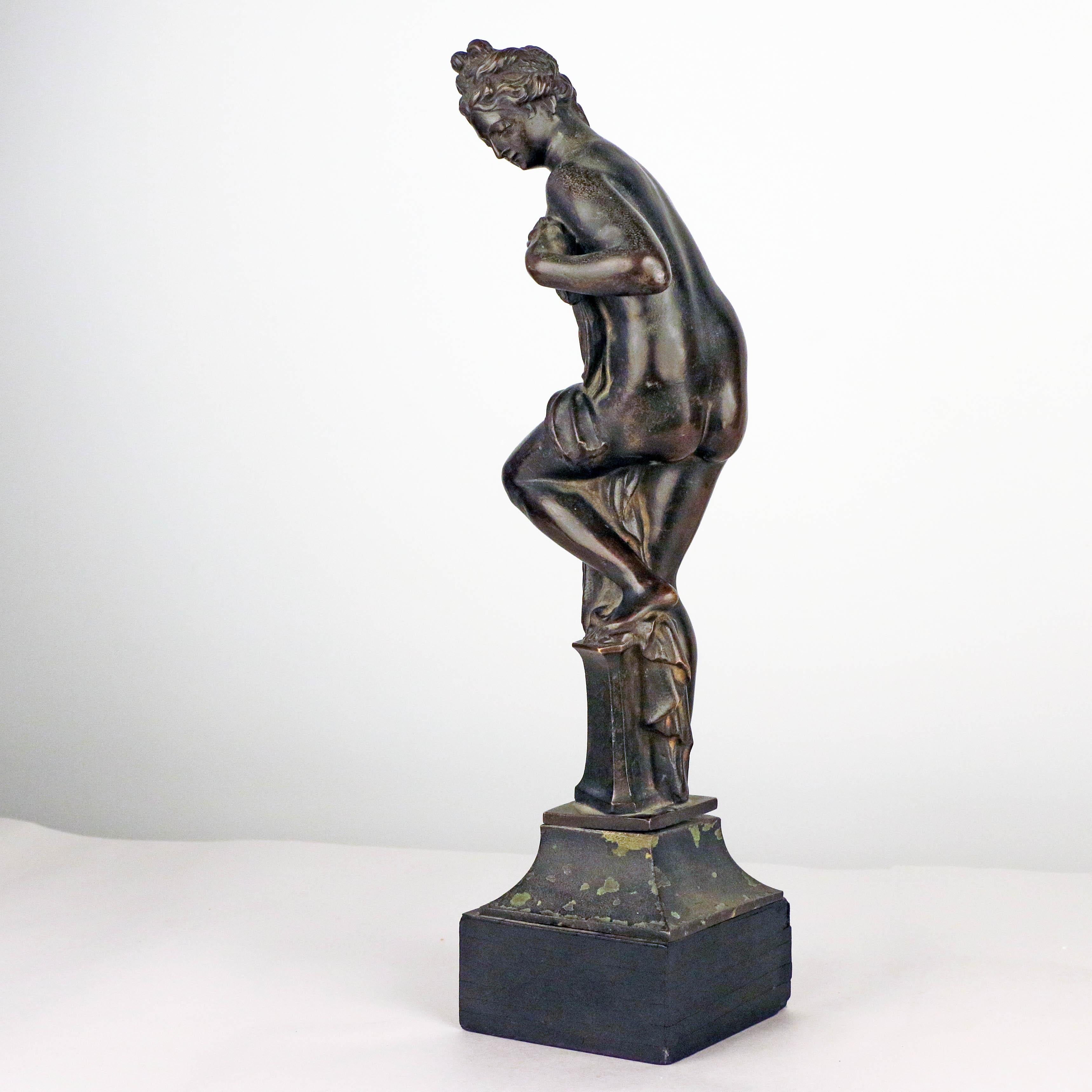 This charming reduction is indisputably antique. It has a wonderful patina, slightly disturbed at the raised heal and more shiney on her bottom (a result of whistful carressing, no doubt). It is offered mounted on a spelter shaped plinth with