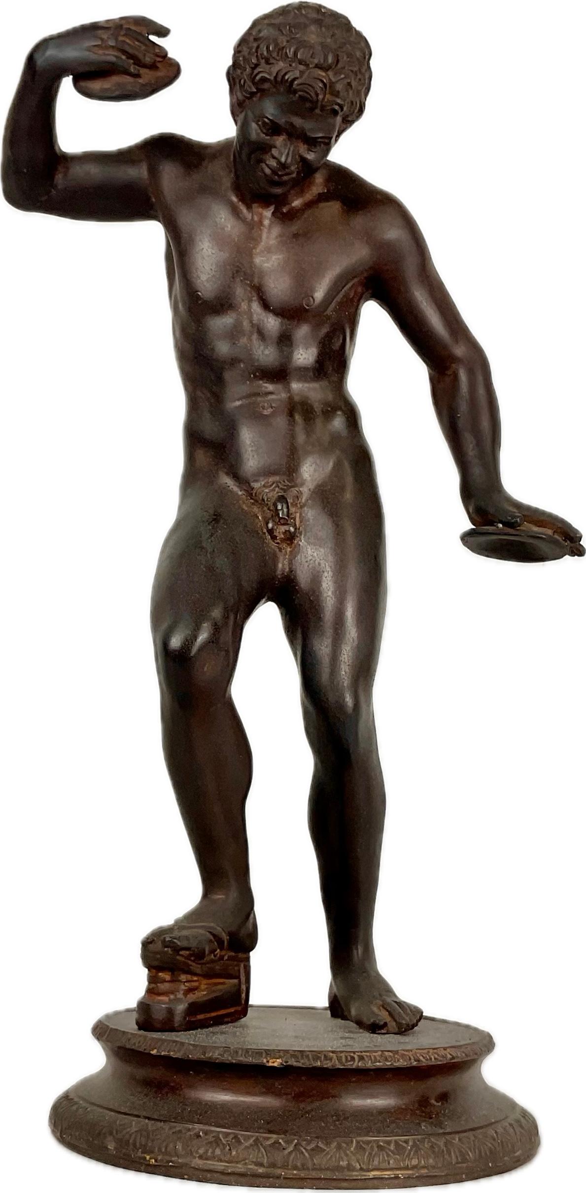 Escultura de Narciso en bronce Grand Tour del siglo XIX. Narciso aparece en un momento de autorreflexión, de pie, en una postura contemplativa. Su forma idealizada resalta su físico juvenil y atlético, centrándose en la precisión anatómica y el