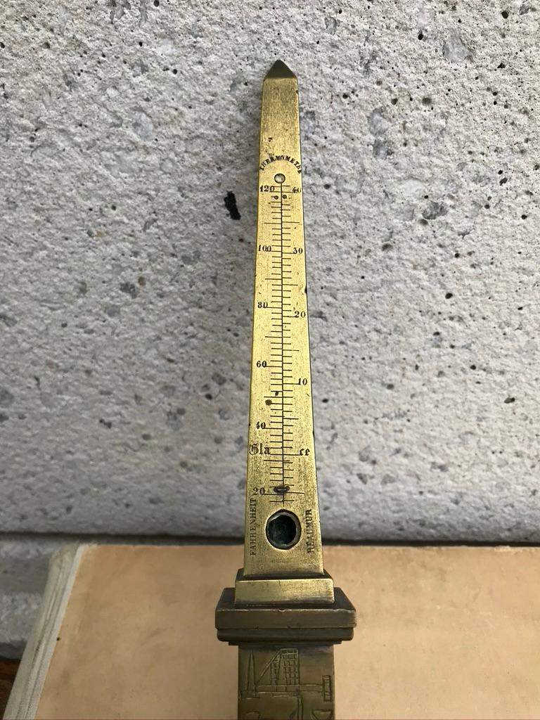 A bronze cast of the Luxor Obelsik, with one side fitted for a thermometer. This was a popular Grad Tour souvenir in the late 19th century. Now missing the glass tube.
10.5 inches high 4 by 4 base

The Luxor Obelisk is over 3,000 years old and