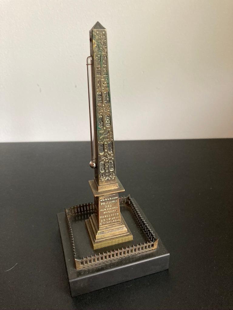 A bronze cast of the Luxor Obelsik, one side a thermometer. This was a popular Grad Tour souvenir in the late 19th century. Mounted on a polished black slate base.
8.5 inches high by 3.5 by 3.5 

The Luxor Obelisk is over 3,000 years old and was
