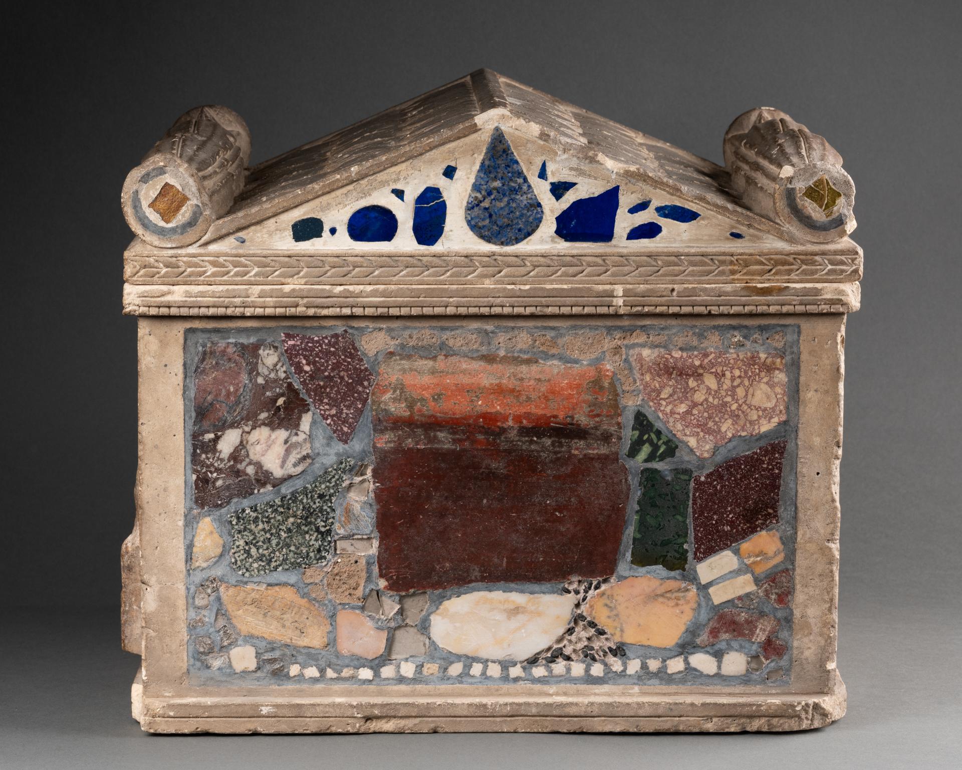 Cinerario Grand Tour del XVIII secolo
Pietra calcarea, intarsiata con frammenti di marmo romano e affreschi
Annotazione di ritrovamento di macchie scritte in modo indistinto sui frammenti (