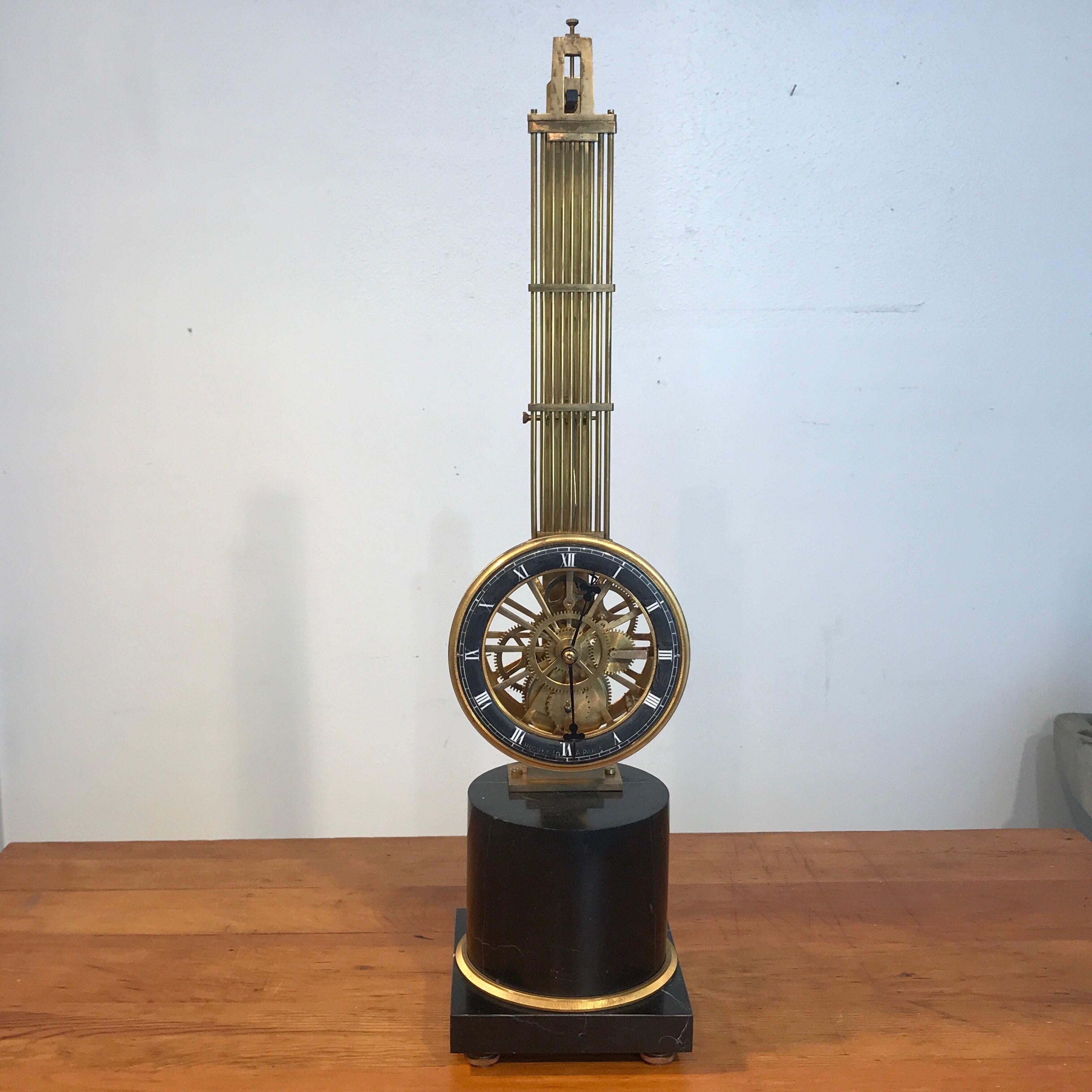 Grand tour column skeleton clock, A. Huguenin, Paris. Swinging column with exposed work and enameled dial. Raised on a footed circular ormolu-mounted marble pedestal base. Working condition. The clock stands 27 inches high, the base has 6 inch