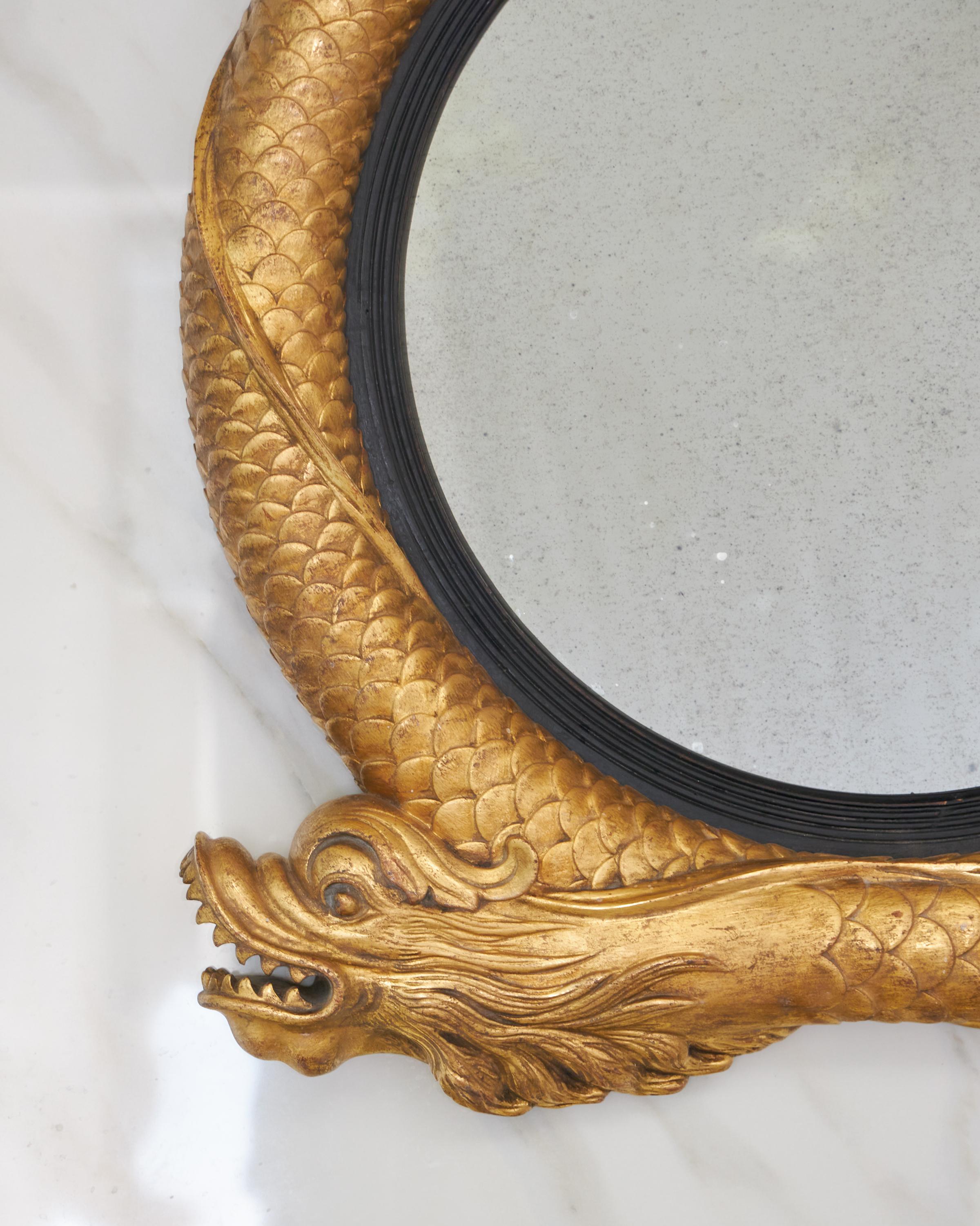 Miroir convexe en forme de dauphin stylisé sculpté et emboîté de style Régence. Finition sur mesure disponible.