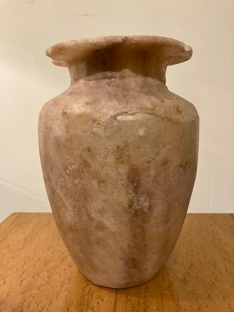 19th century hand carved alabaster storage jar in the ancient Egyptian Late Dynastic style, with tapering neck topped by a wide everted rim. Great evocative decorative piece for the mantle, table or bookshelf.
Measures: 10 inches high by 7.5