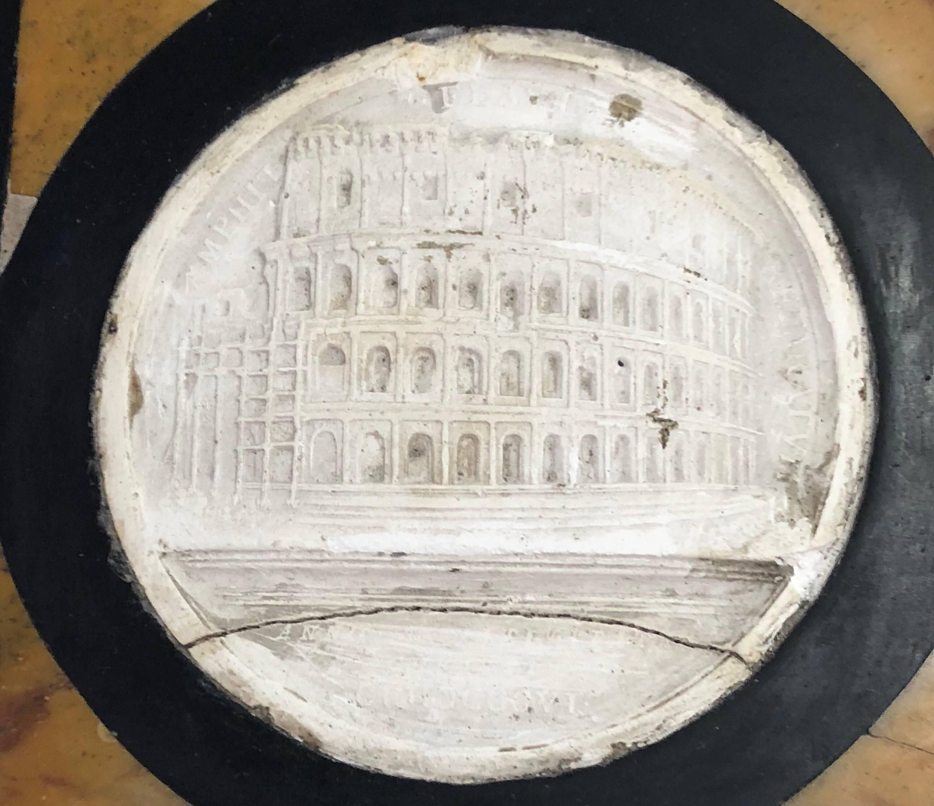 The paperweight inset with a plaster cast of the Coliseum, outlined in 'marmo nero' and marmo giallo.