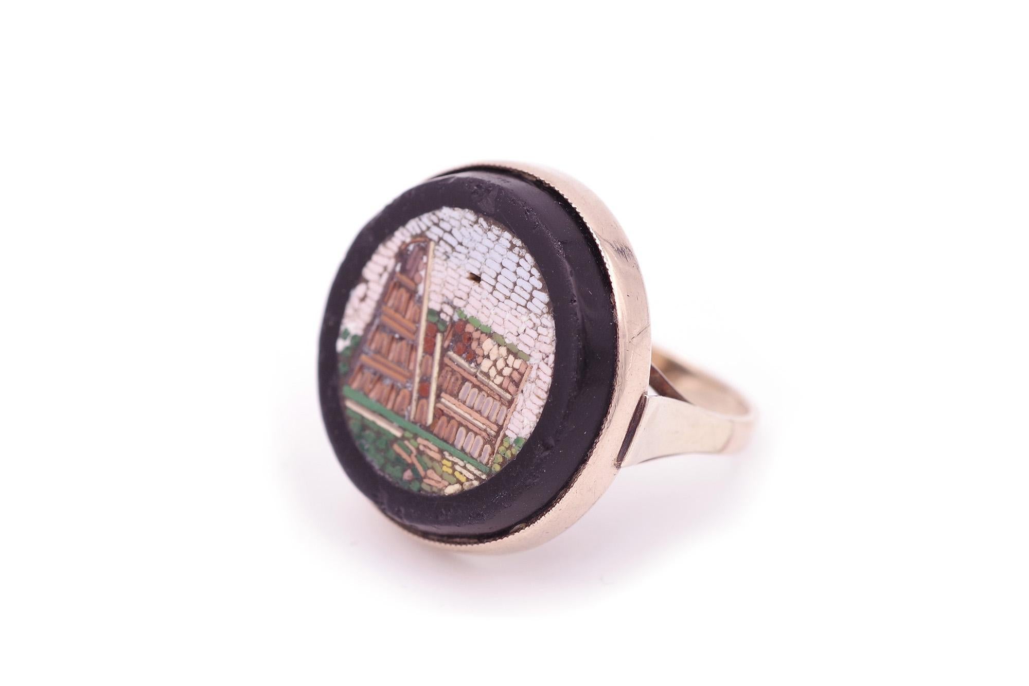 Anello Grand Tour a micro-mosaico in oro 9 carati. Anello antico di epoca vittoriana, souvenir del Grand Tour, con incastonato un micro-mosaico circolare che rappresenta il Colosseo di Roma. La lastra di vetro è incastonata in oro a 9 carati. Anello