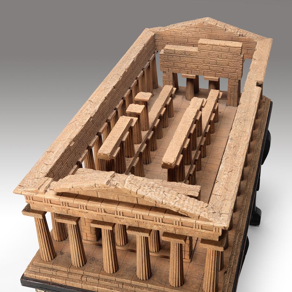 A fine Grand Tour design copy of the temple of Poseidon. The temple made in carved wood and specialist paint finished. The Temple is fixed to a 19th century wooden base which in turn is mounted on a bronze mounted cabriole ebonized table base with