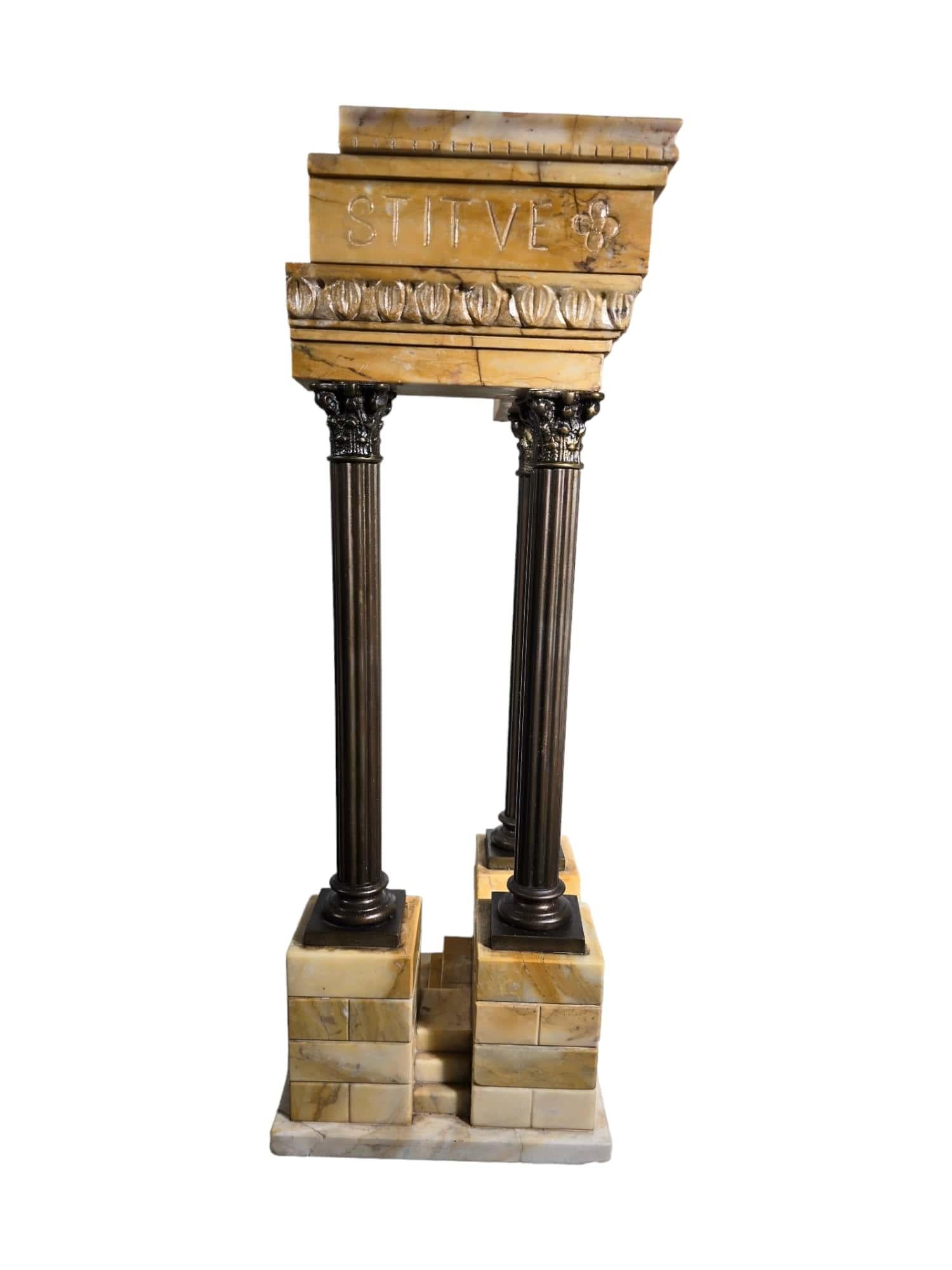 Ce modèle exquis du temple de Vespasien, réalisé en marbre Giallo Antico et en bronze, illustre le savoir-faire exceptionnel et la maîtrise artistique de l'époque du Grand Tour. Créée dans un atelier italien vers 1920, cette pièce témoigne de la