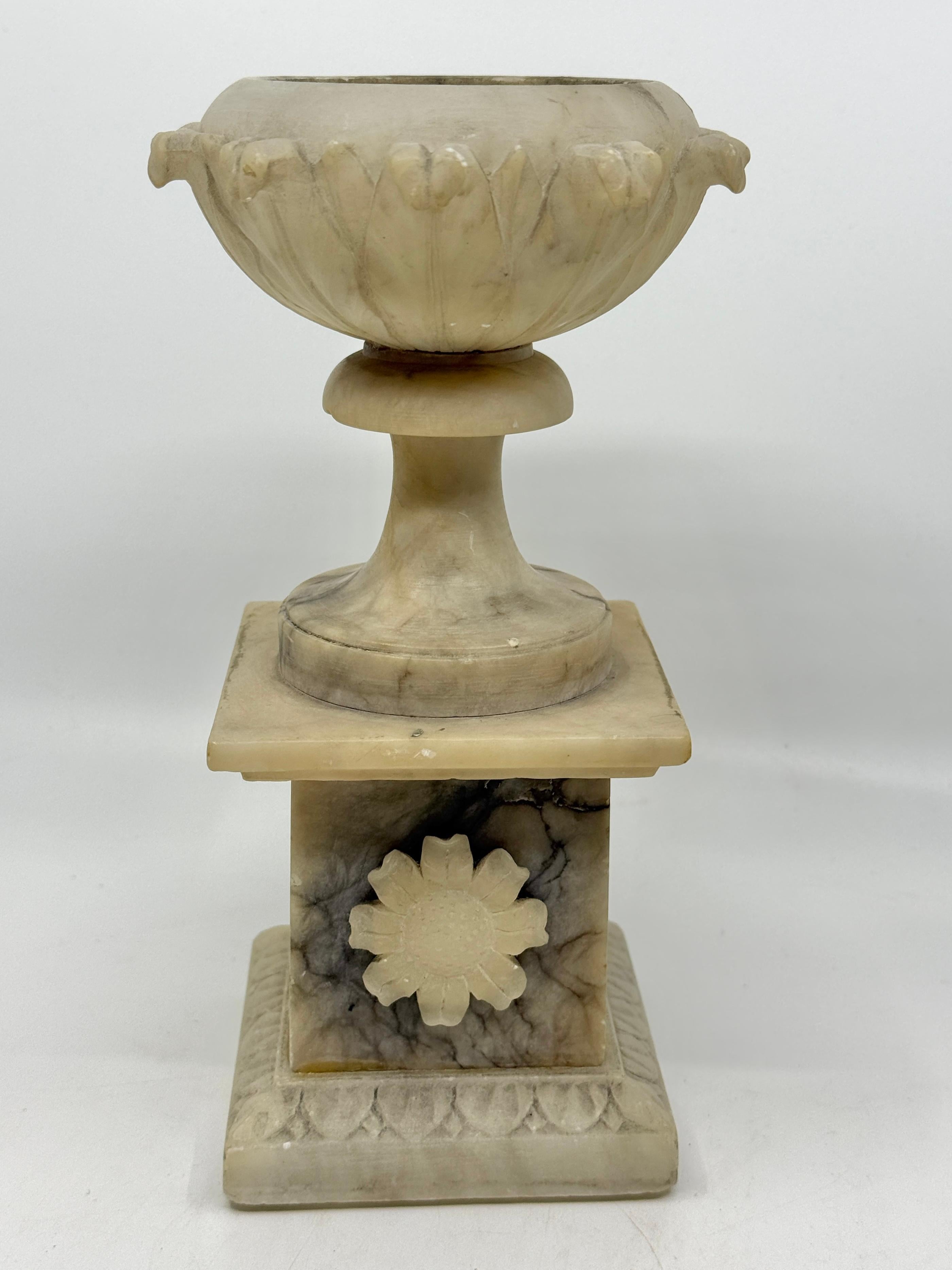 A nice neoclassical grand tour souvenir of an urn carved out of alabaster. The urn is was carved in pieces and assembled. 
Nice veining to the alabaster. 

Good antique condition. Some chips and scratches, two apertures to either side of the rim.