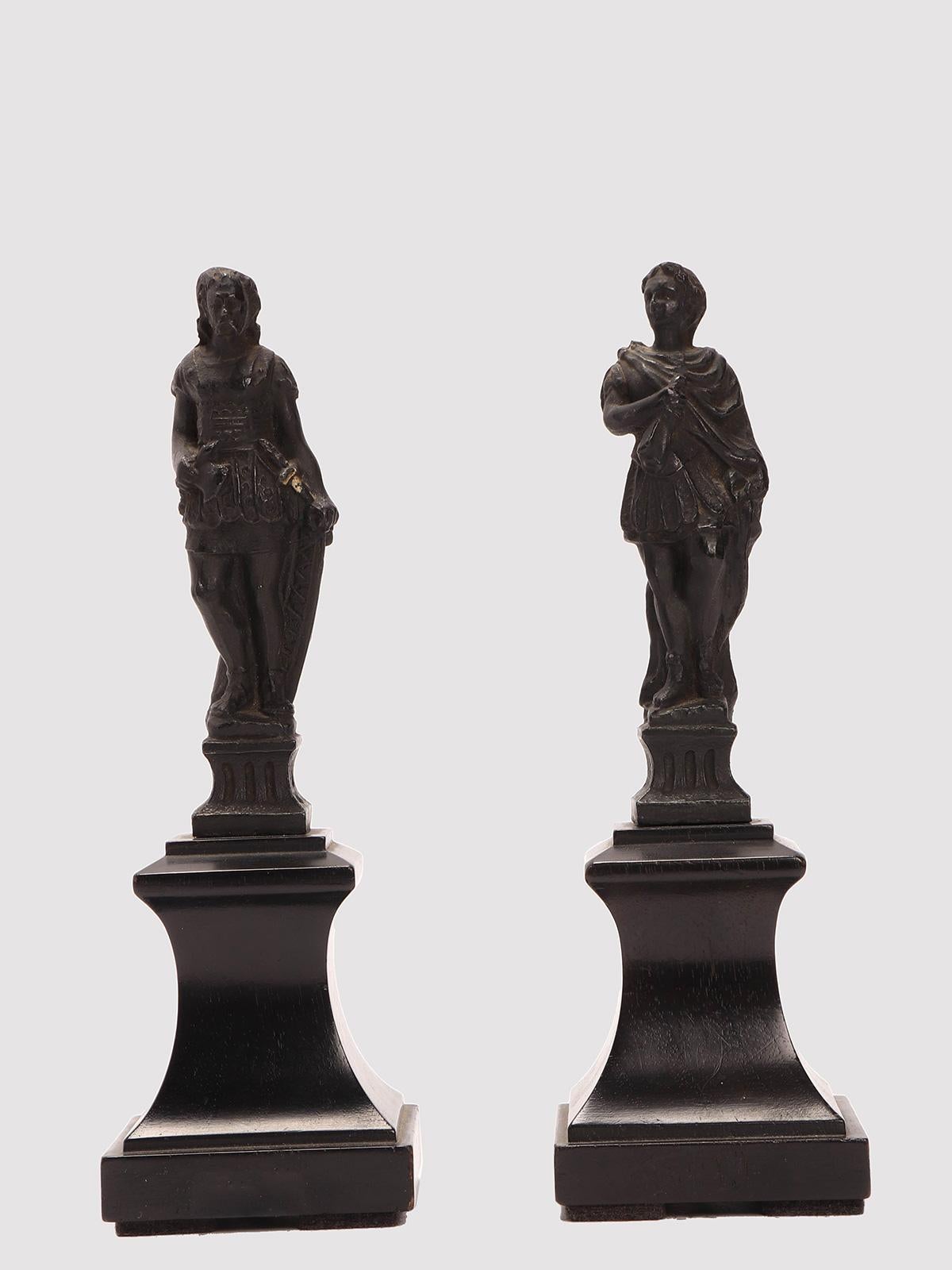 Objet du Grand Tour d'Italie : Paire de petites sculptures en métal blanc et finition bronze, représentant un législateur romain et un guerrier, montées sur une base en bois d'ébène. Venise, Italie vers 1880.