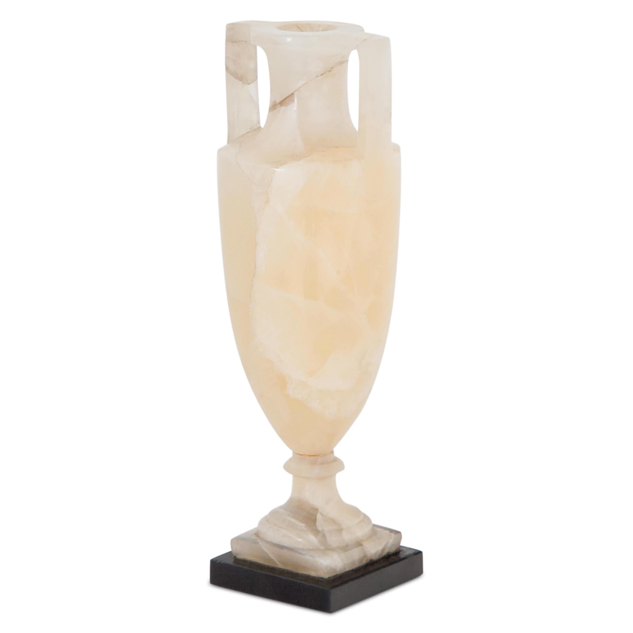 Small amphora out of light yellow alabaster in a classical shape with a slender body, long straight handles and a slim neck with accentuated shoulder. On a small black stone base.