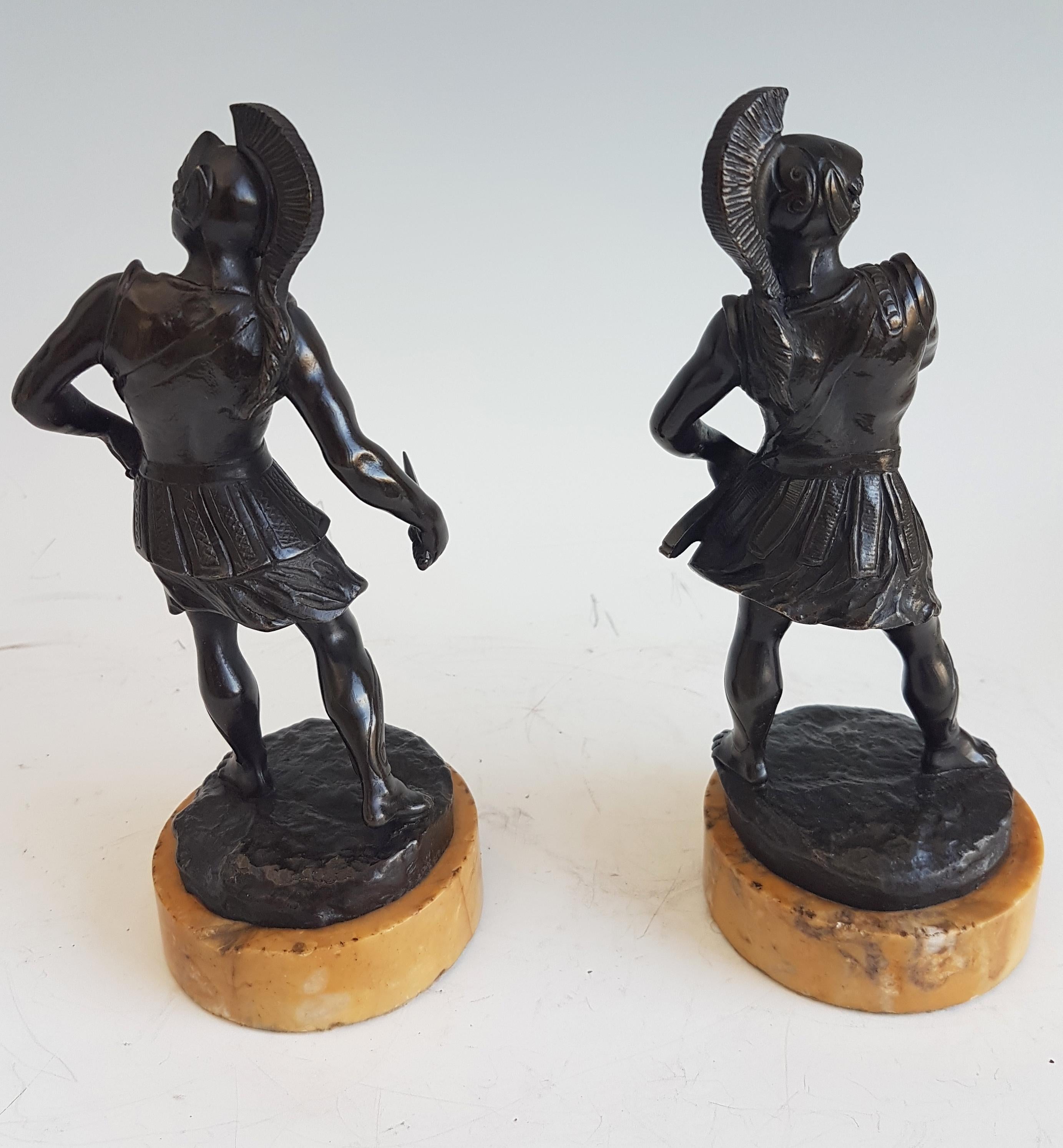 A fine pair of Italian grand tour patinated bronze gladiators. One with his dagger drawn, the other about to draw his. Both in plumed helmets. Superb original patination and detail. Set on fine sienna marble bases.