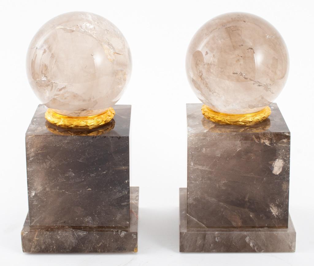 Pair of Grand Tour Revival smoky quartz spheres upon gilt bronze laurel wreath stands mounted atop smoky rock crystal bases, the mineral specimens with inclusions and rainbows. Each overall: 12.75