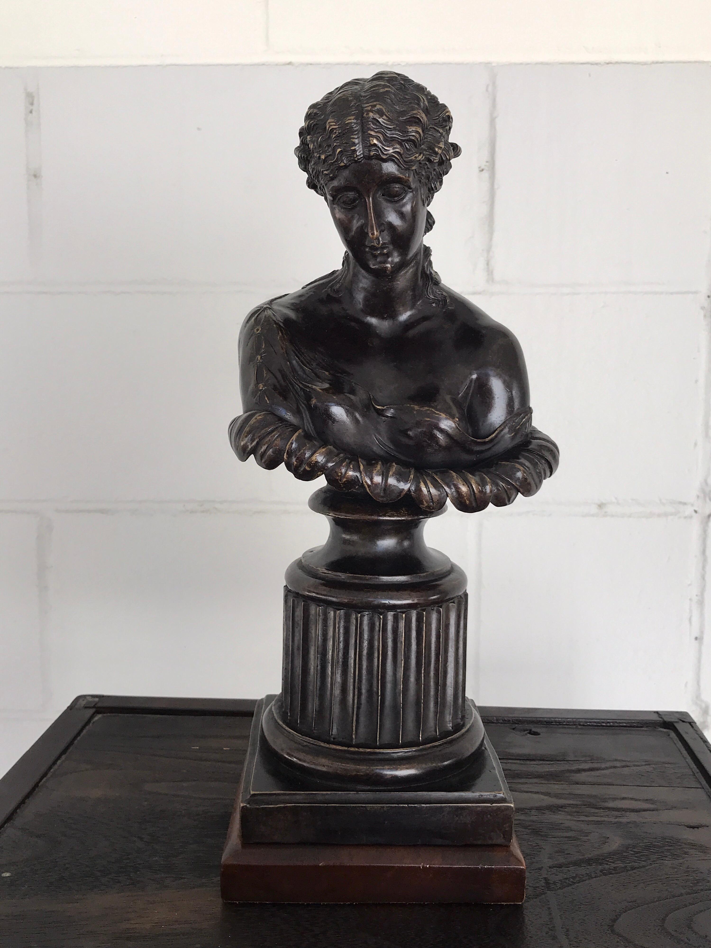 Buste en bronze de style Grand Tour de Clytie, d'après l'antique, la nymphe au visage abattu et peu drapé, coiffée d'une grande fleur. Élevé sur un socle en bois carré de 6