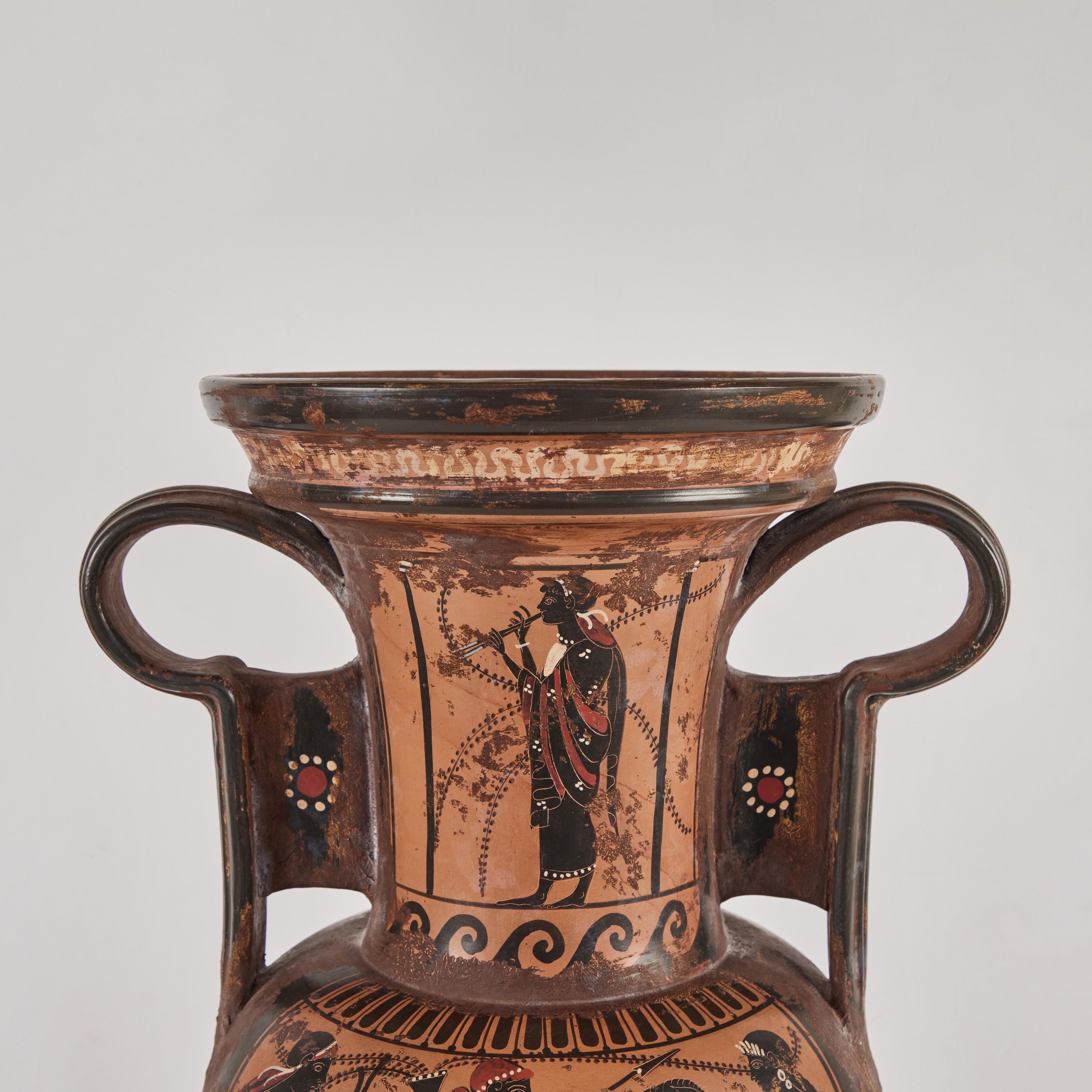 A Grand tour version of an ancient Greek amphora jar. Painted terracotta with figures and horses. The two-handled storage jar held oil, wine, milk, or grain.  This piece dates from late 19th to early 20th century.