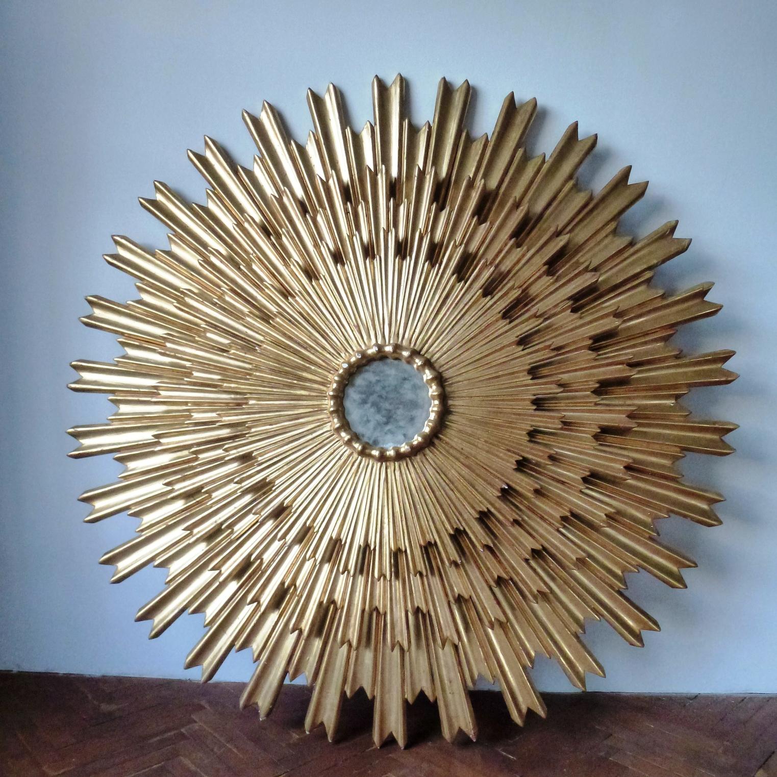 Huge wood carved three tiered sunburst mirror. Gold leaf polished on red bolus. 
Has minor wear signs on different parts and several restoration interventions.
There are visible signs of previous use: scratches, very small cracks and some worn