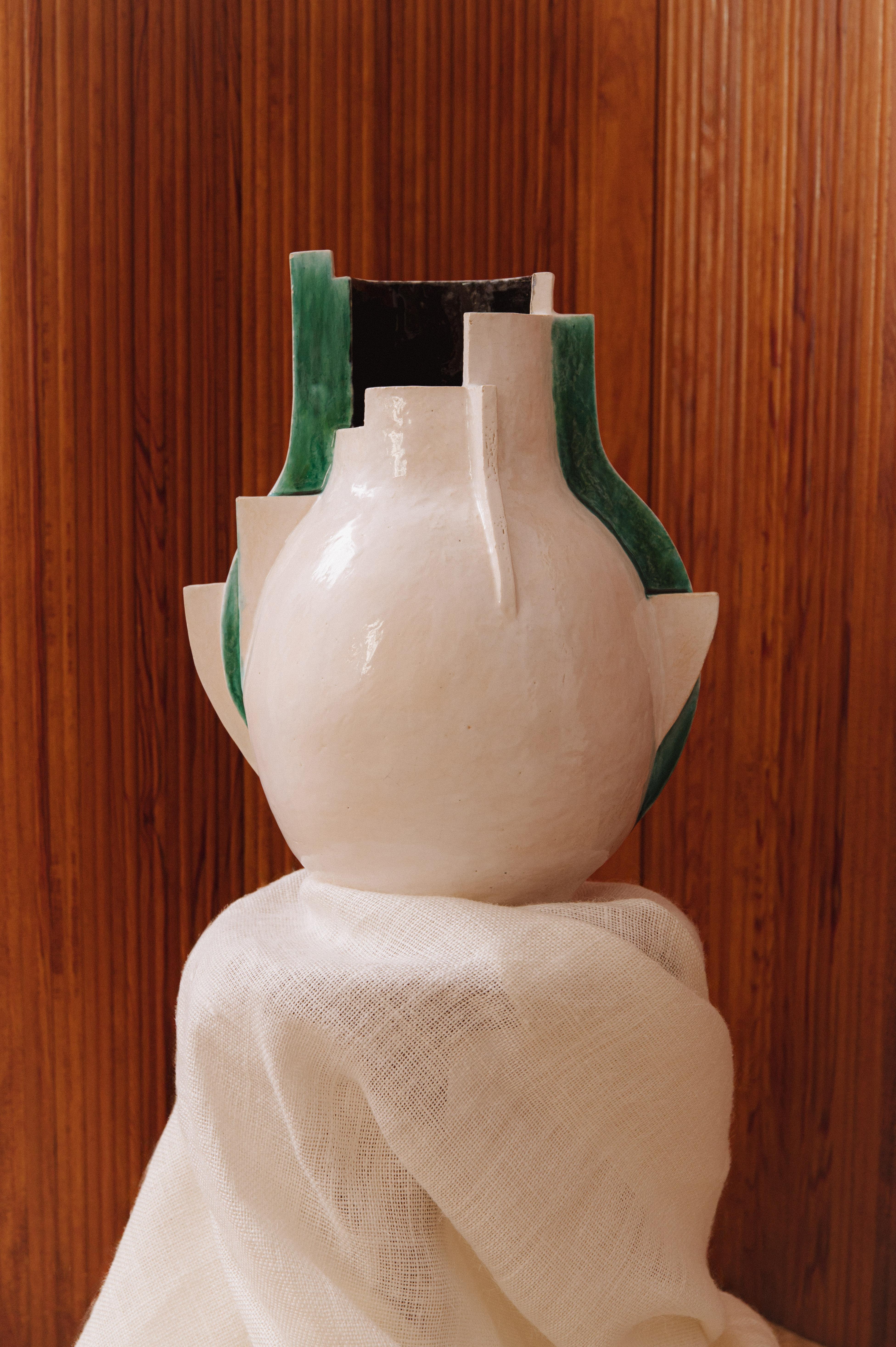 Imposant vase d'un artiste inconnu présentant un design unique et sculptural, typique du milieu du 20e siècle. Sa forme architecturale et ses découpes asymétriques lui confèrent un caractère audacieux, tandis que les couleurs blanc, vert foncé et