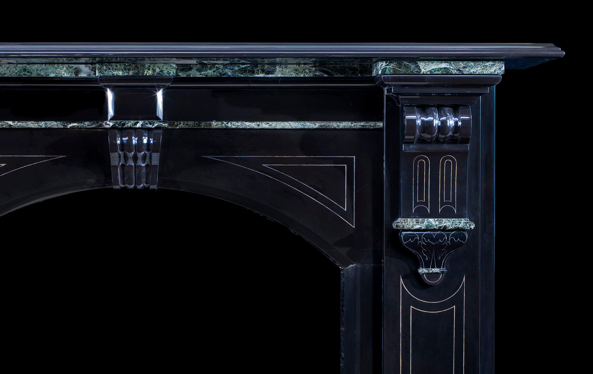 A substantial and grand Victorian fireplace in dramatic Belgian black marble. The large and wide moulded shelf sits over a verde antico undershelf, and is centred by a beautifully carved keystone above the slow arch which is emphasised by the