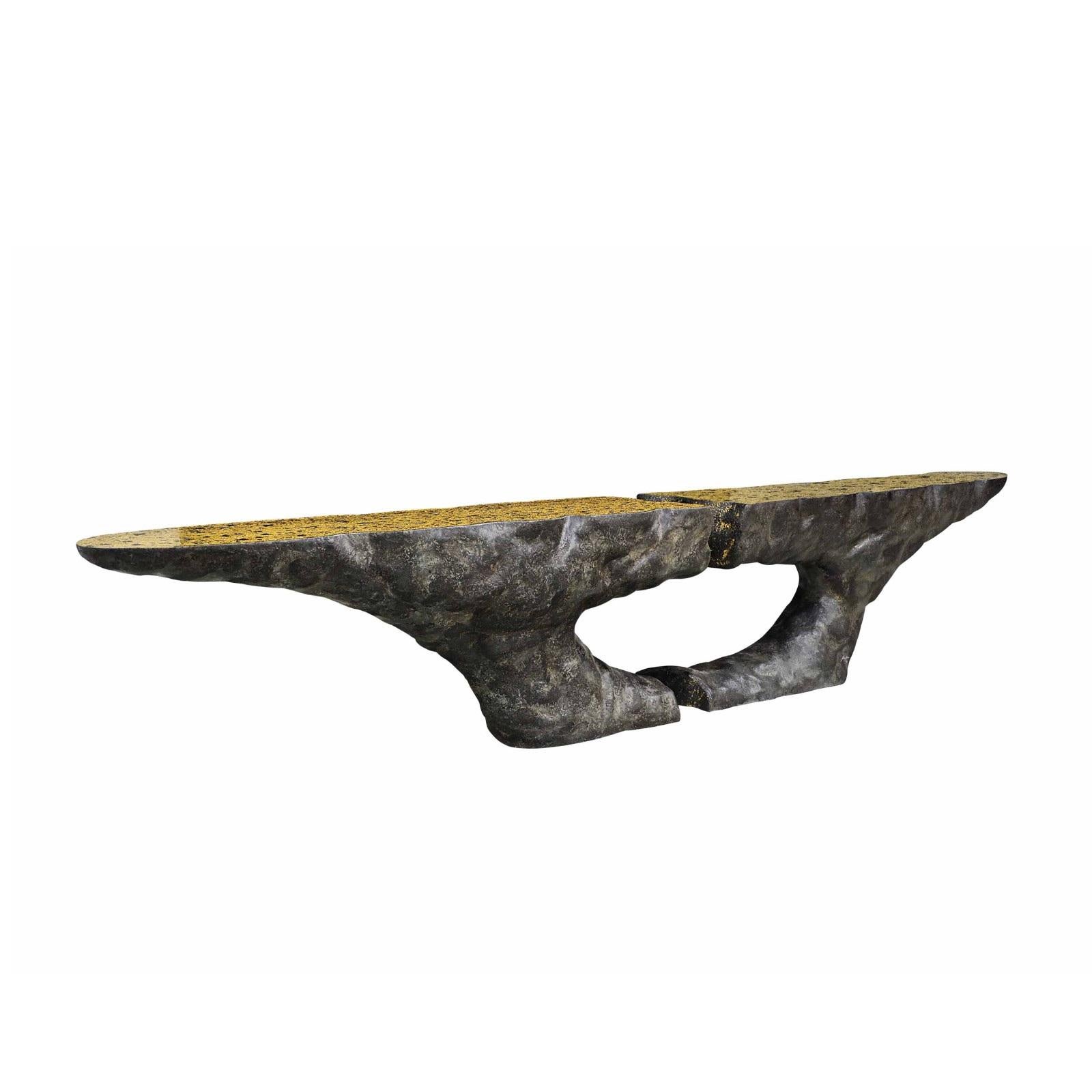 This console has a volcanic finish that gives it a natural and raw beauty, displaying textures inspired by volcanic formations in nature. The top of the console is textured gold leaf, bringing a touch of luxury and elegance to its overall