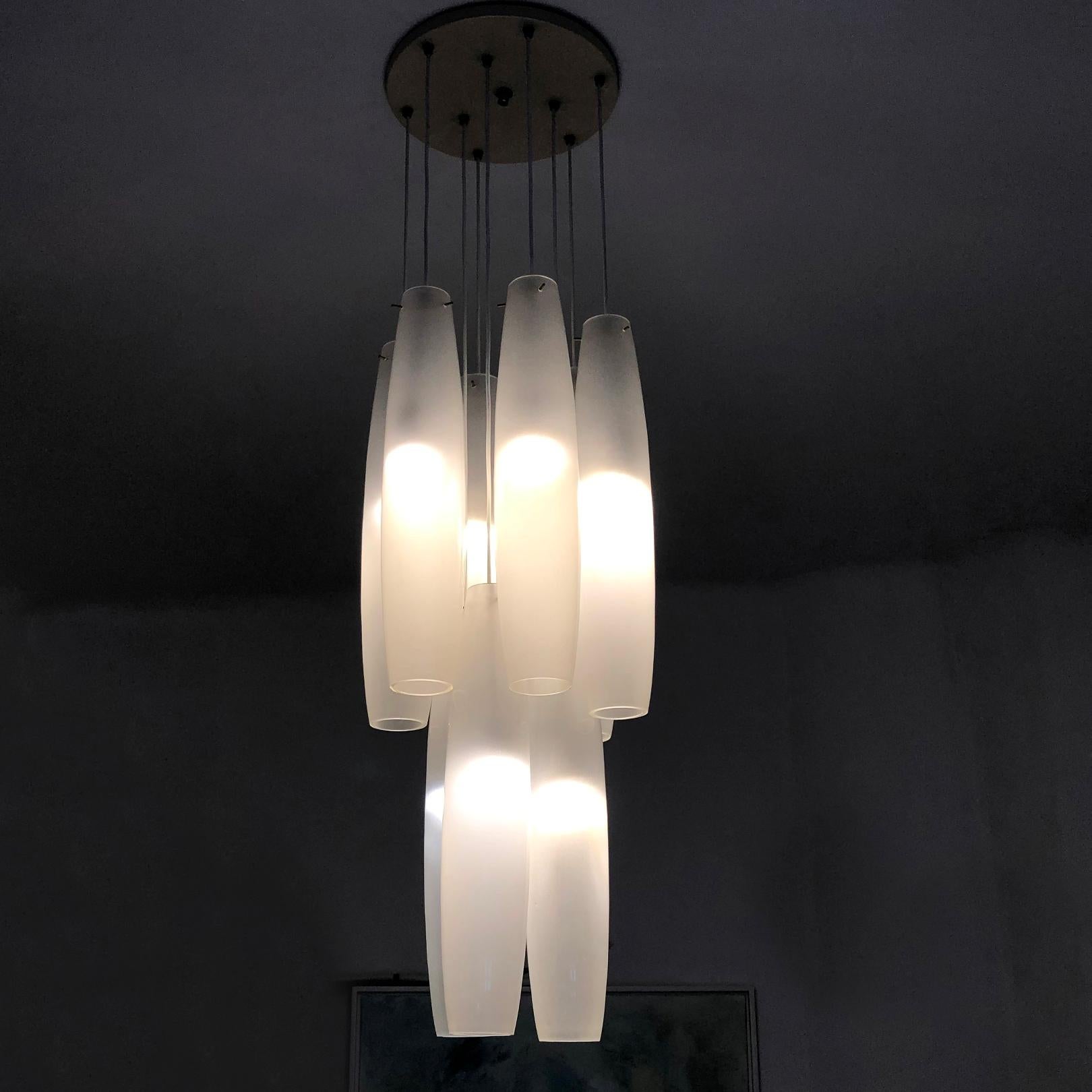 Very big chandelier consisting of 9 white pendants. Each pendant is 65 cm (25.5 in) long and 14 cm (5.5 in) in diameter.
Nine tubes are attached to a beige enameled metal ceiling rose which is fastened to the ceiling by chrome-plated nut.
The