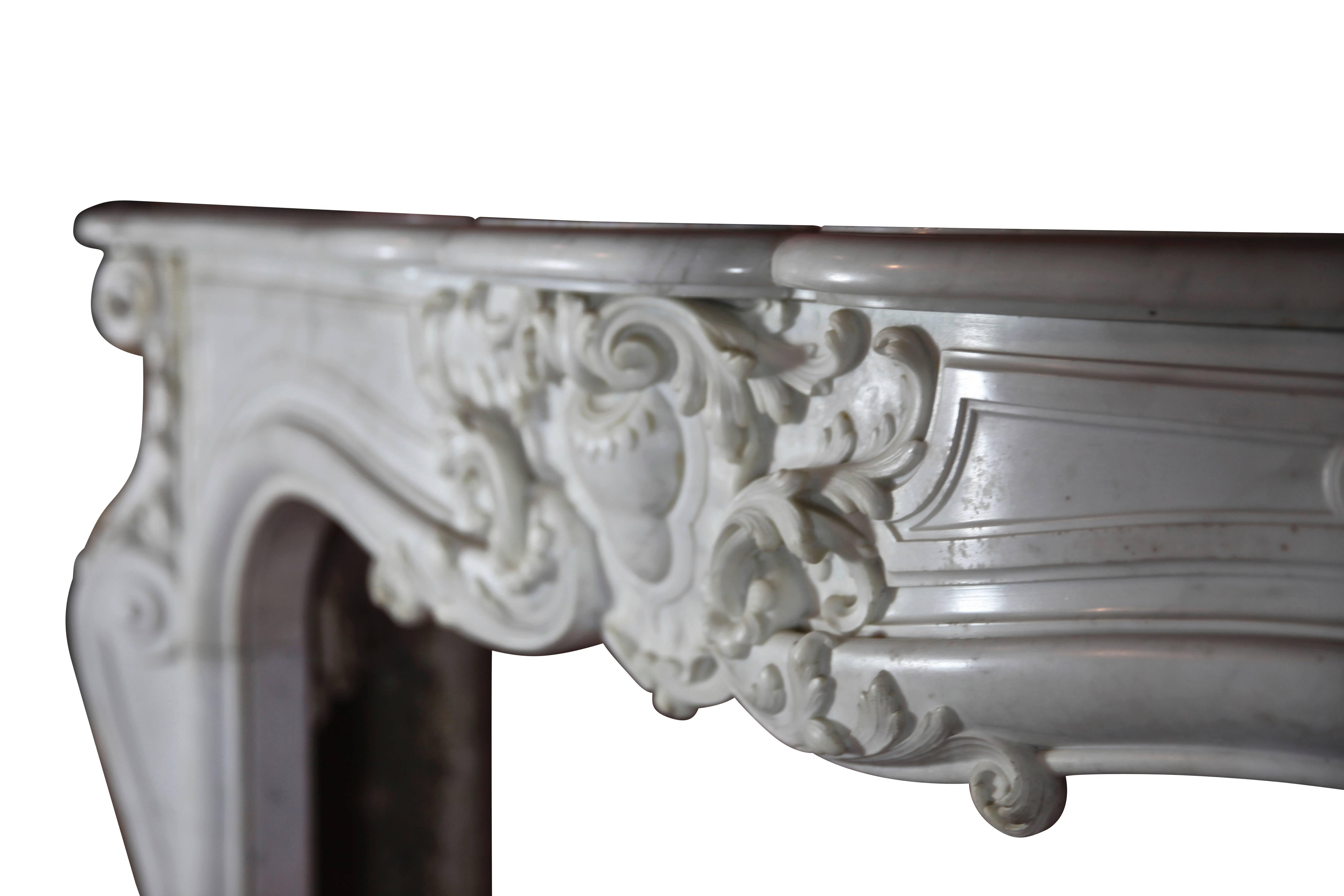 A very state of the art antique fireplace surround in white statuary marble from the Rococo period; the surround is in perfect condition. There is extraordinary waving side panels on the jambs. The moulding is called 