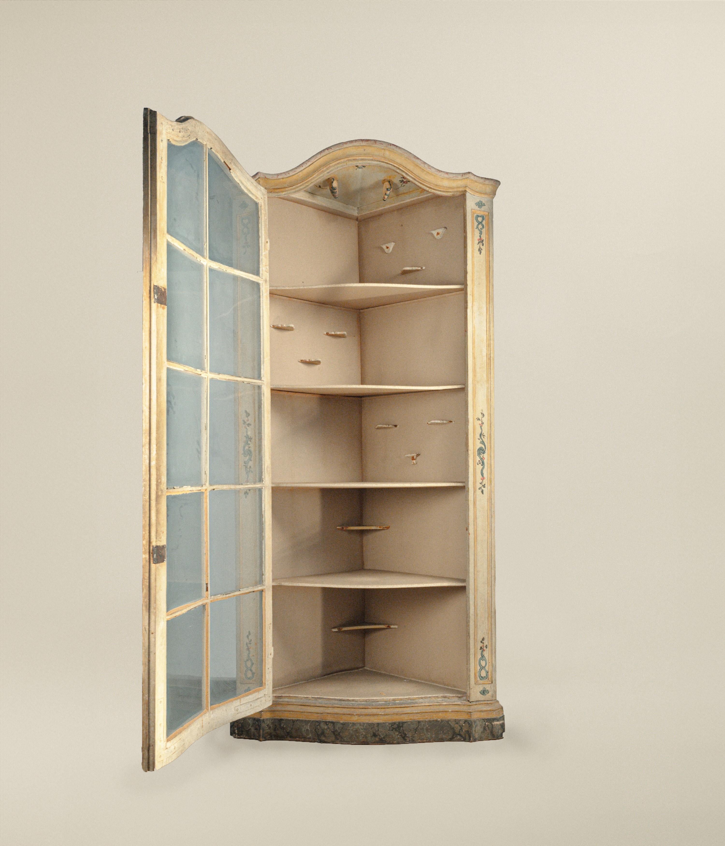 decorado en su totalidad con pequeñas flores sobre fondo marfil, frente ligeramente convexo con puerta de cristal cuadrada, cornisa moldurada y redondeada, banda de base decorada con imitación de mármol, (lacado no coetáneo)