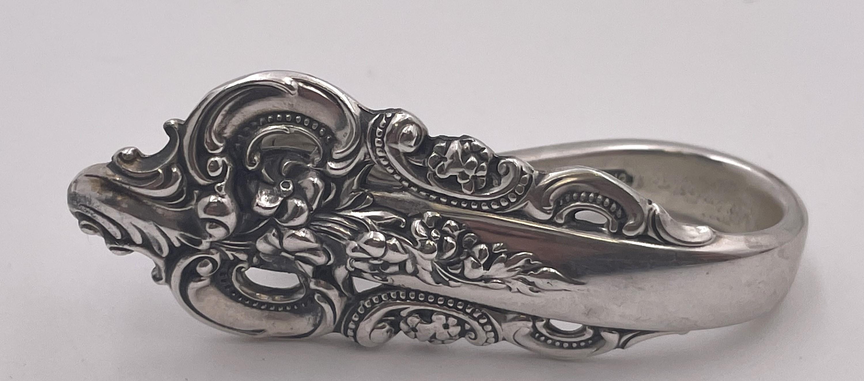 Set of 12 Wallace Grande Baroque original sterling silver napkin clips from the mid-20th century. They measure 2 1/3'' in length by 3/4'' in depth, weigh 8.8 troy ounces, and bear hallmarks as shown.

Wallace Silversmiths is a major American