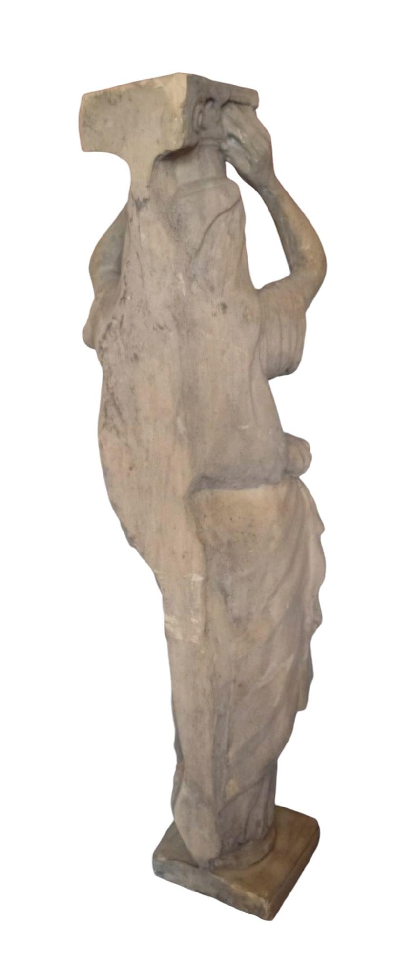 Introducing an exquisite Grande Cariatide in Antique Style crafted from reconstituted stone, representing a draped woman in the classical antique style, supporting an Ionic capital. This stunning piece from the second third of the 20th century is a