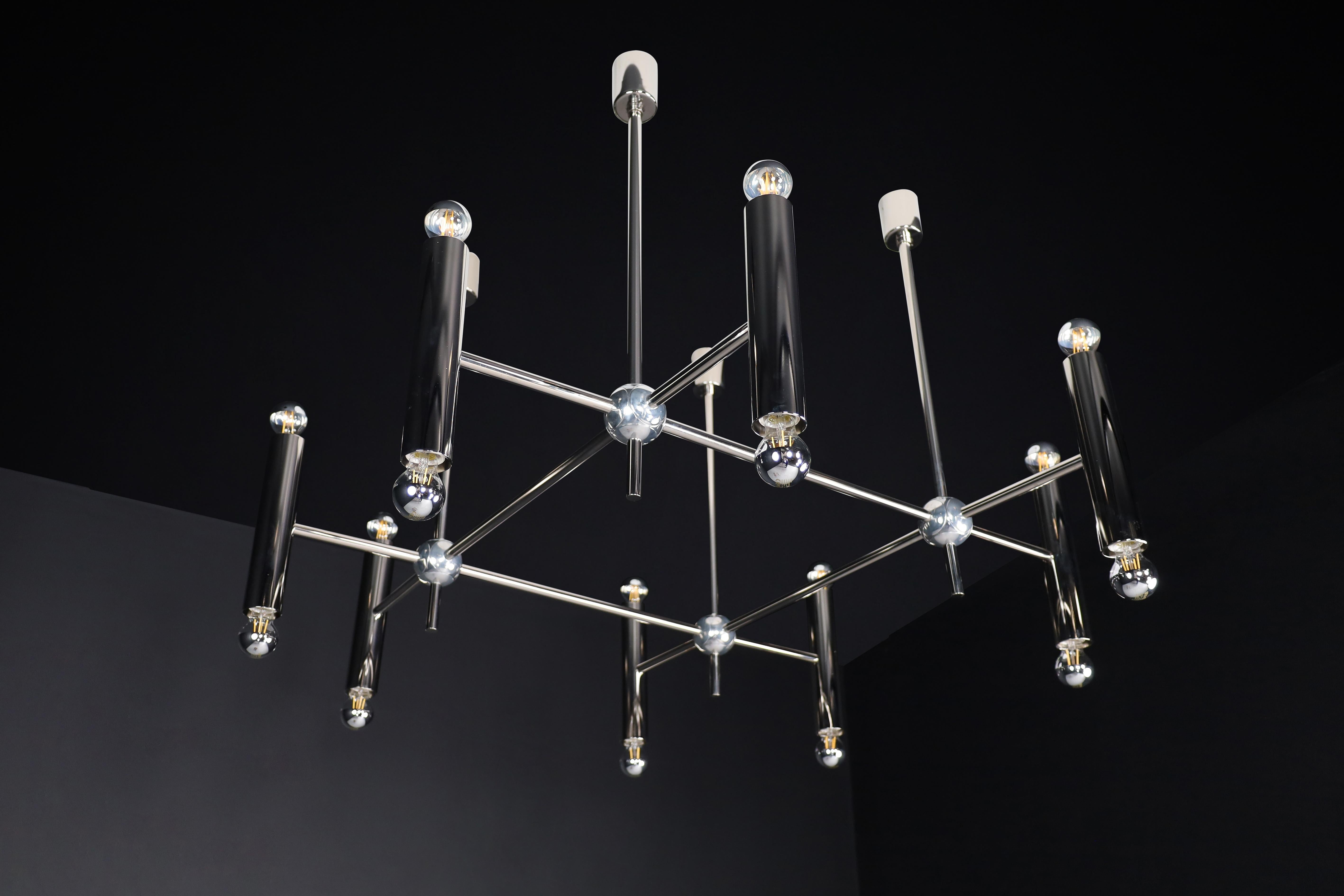 Grande Chandelier in Polished Steel with 16 Lights Germany 1960s.

This is a magnificent midcentury chandelier made in Germany during the 1960s. The chandelier features a polished steel frame and eight tubes held together by steel. Each tube has
