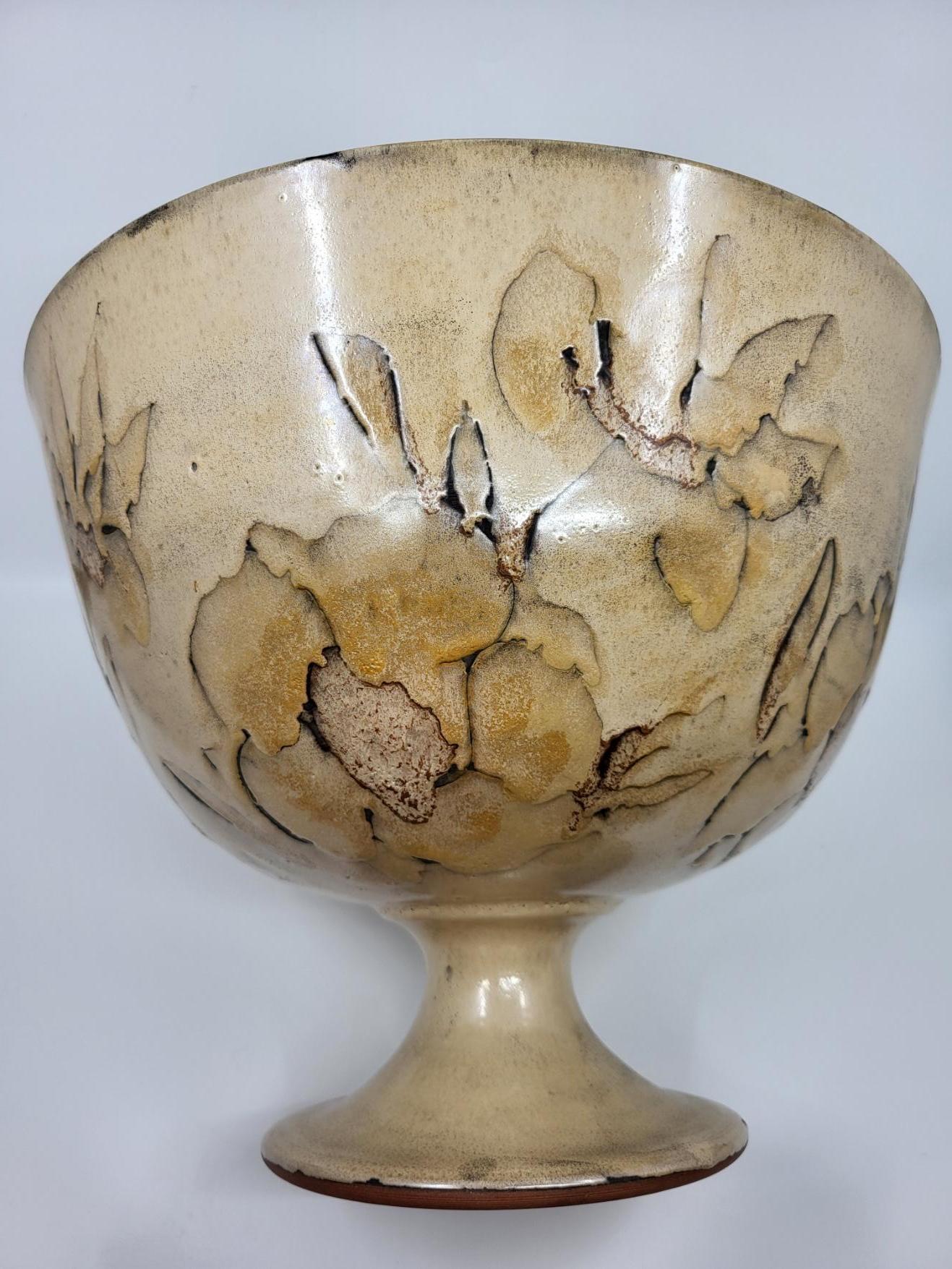 Cette belle coupe en céramique émaillée beige, de très grandes dimensions, arbore un décor incisé floral qui captive par sa délicatesse. En magnifique état, elle a traversé les décennies sans aucune éraflure ni dommage, ce qui témoigne de son
