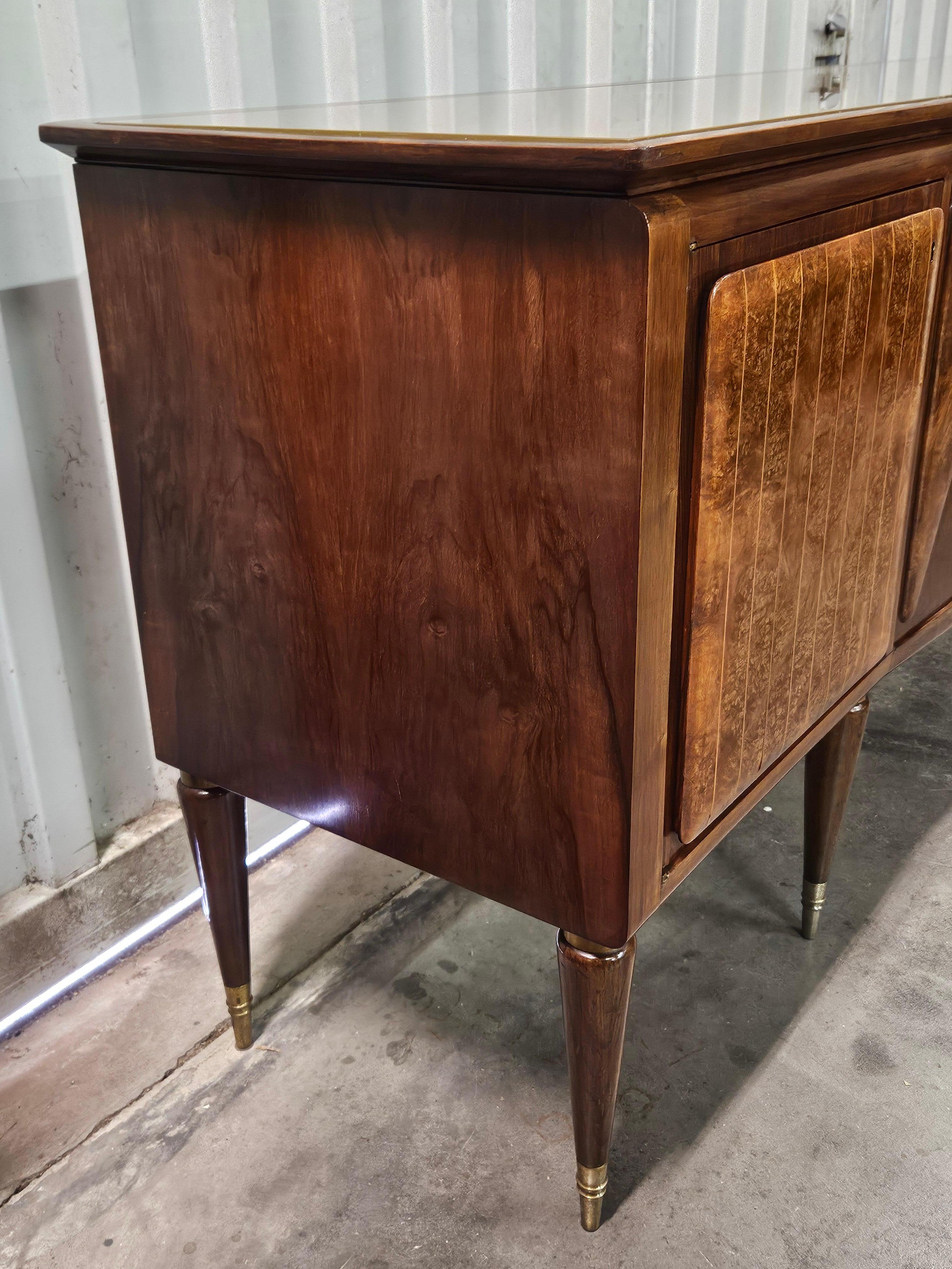Elegant sideboard of mid-20th-century Italian origin, high quality production and workmanship in walnut with maple fillets on doors and interior drawers.

The cabinet has a curved glass top at the front, five doors where we find solid and sturdy