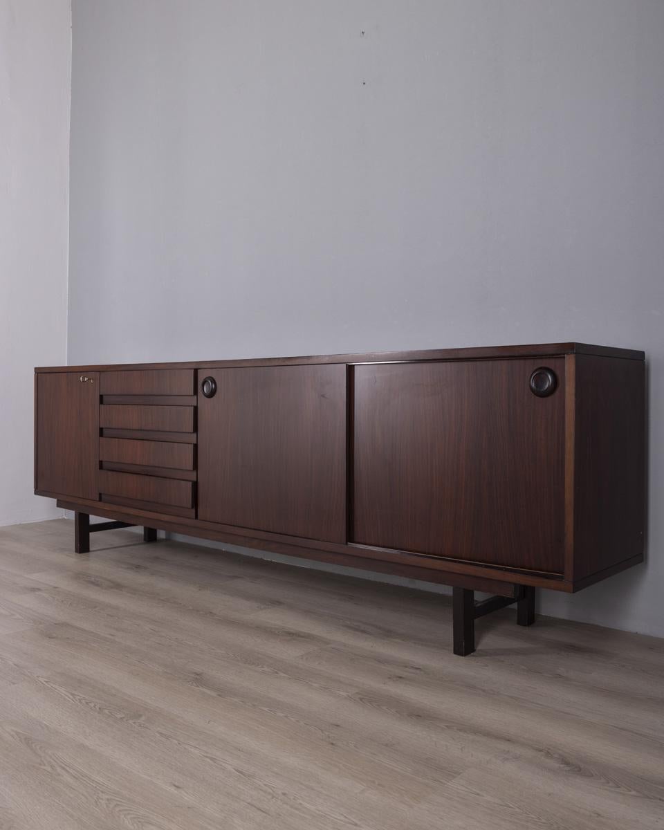 Walnut sideboard with three doors and four drawers, Italian design, 1960s.

CONDITION:
In good condition, may show signs of wear due to age.

SIZING:
Height 76 cm; width 240 cm; depth 43 cm;

MATERIALS:
Wood.

YEAR OF CONSTRUCTION:
1960s.


